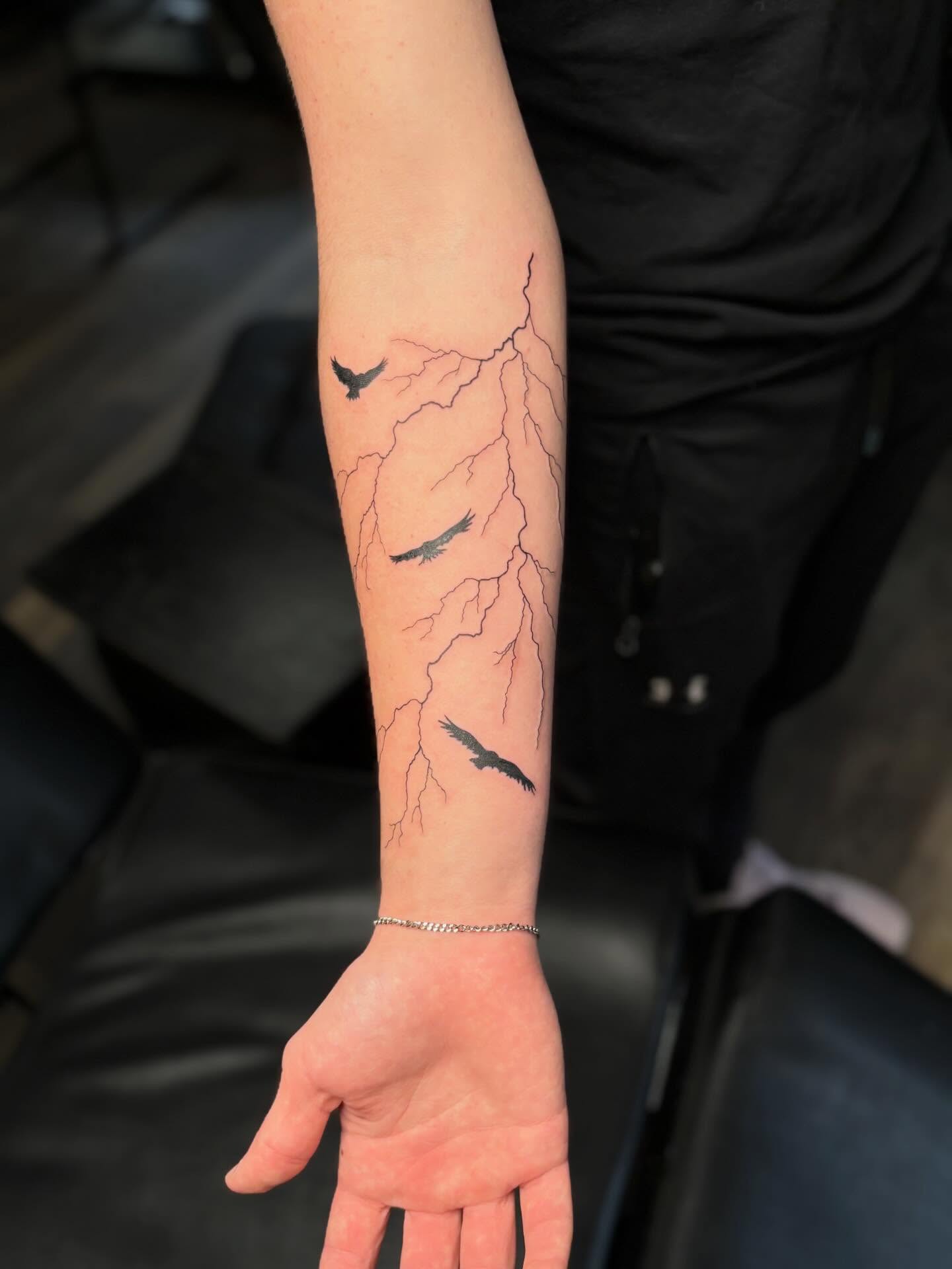 Lightning bolts and birds black and grey tattoo on the forearm by Tessa Simmons - Tattoo Artist