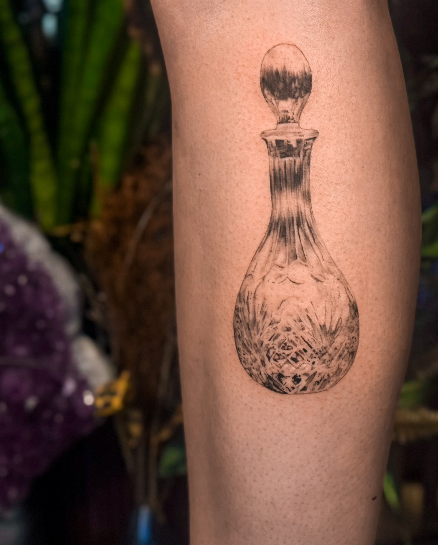 Decanter black and grey tattoo on the thigh by Rose