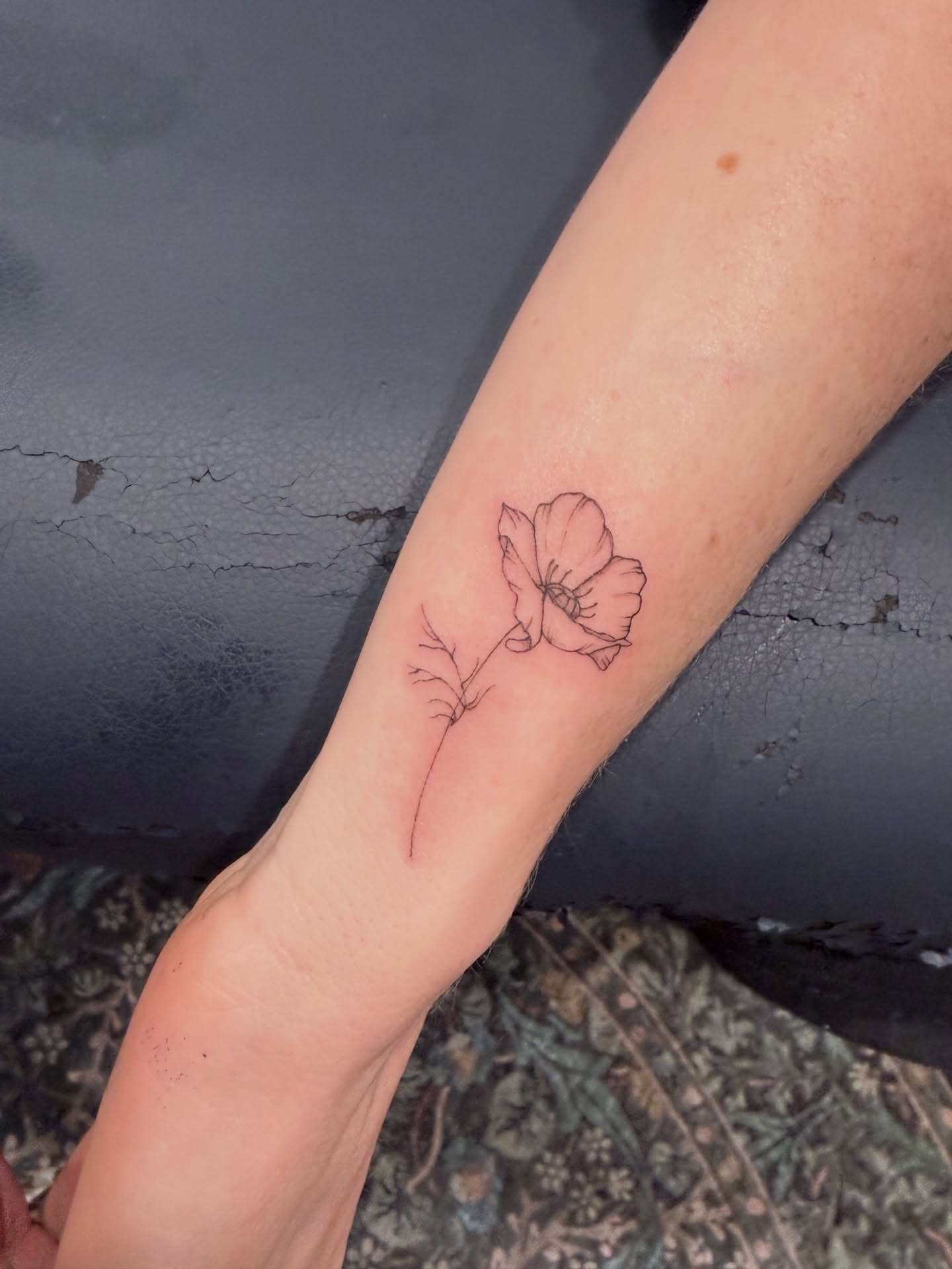 Flower fine line tattoo on the forearm by Reverie Studio