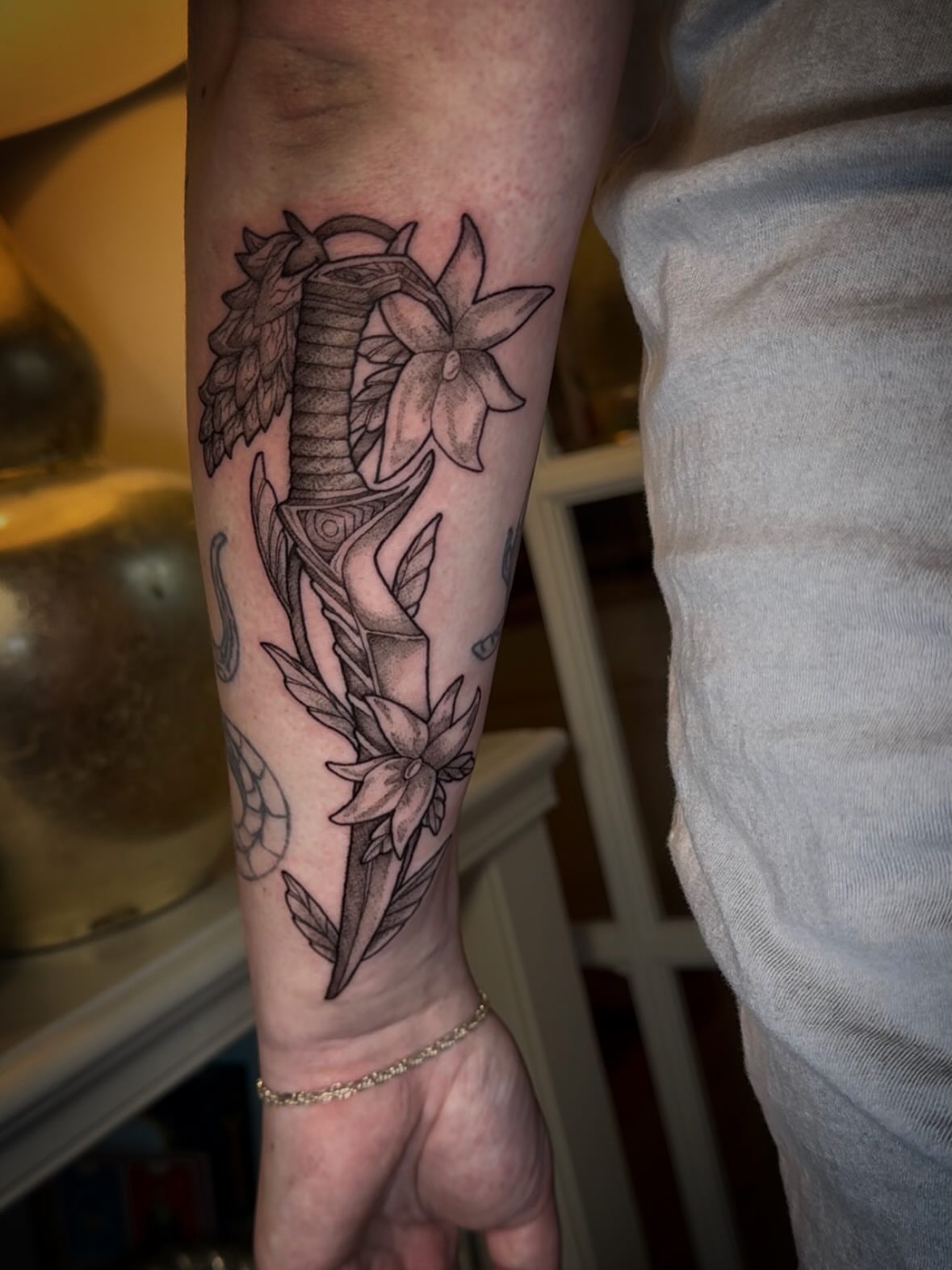 Sword and flowers realism tattoo on the forearm by Tattoos by Alex