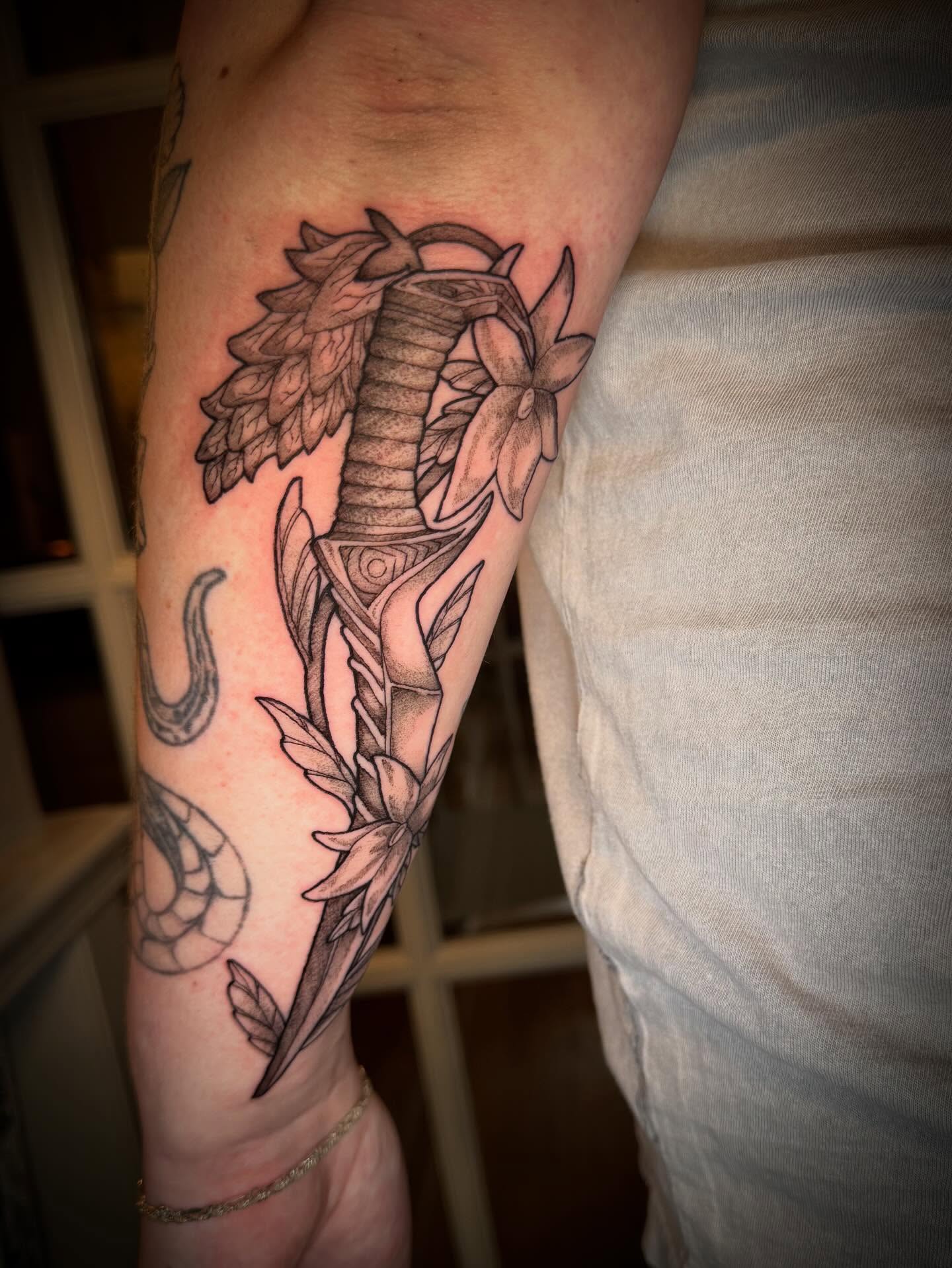 Snake and flowers black and grey tattoo on the forearm by Tattoos by Alex