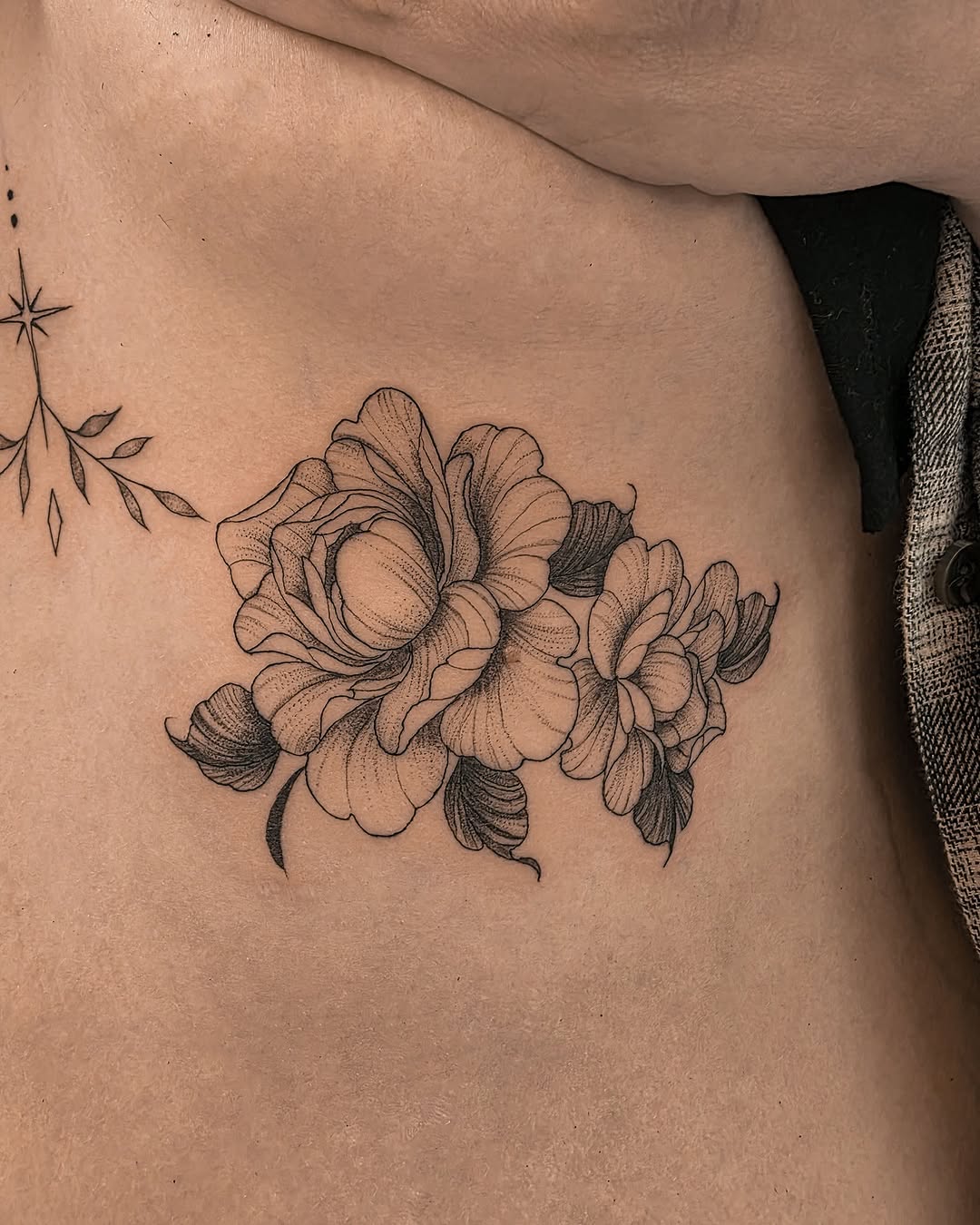 Flowers and star dotwork tattoo on the ribs by Richmond tattoo shop, Richmond, Texas