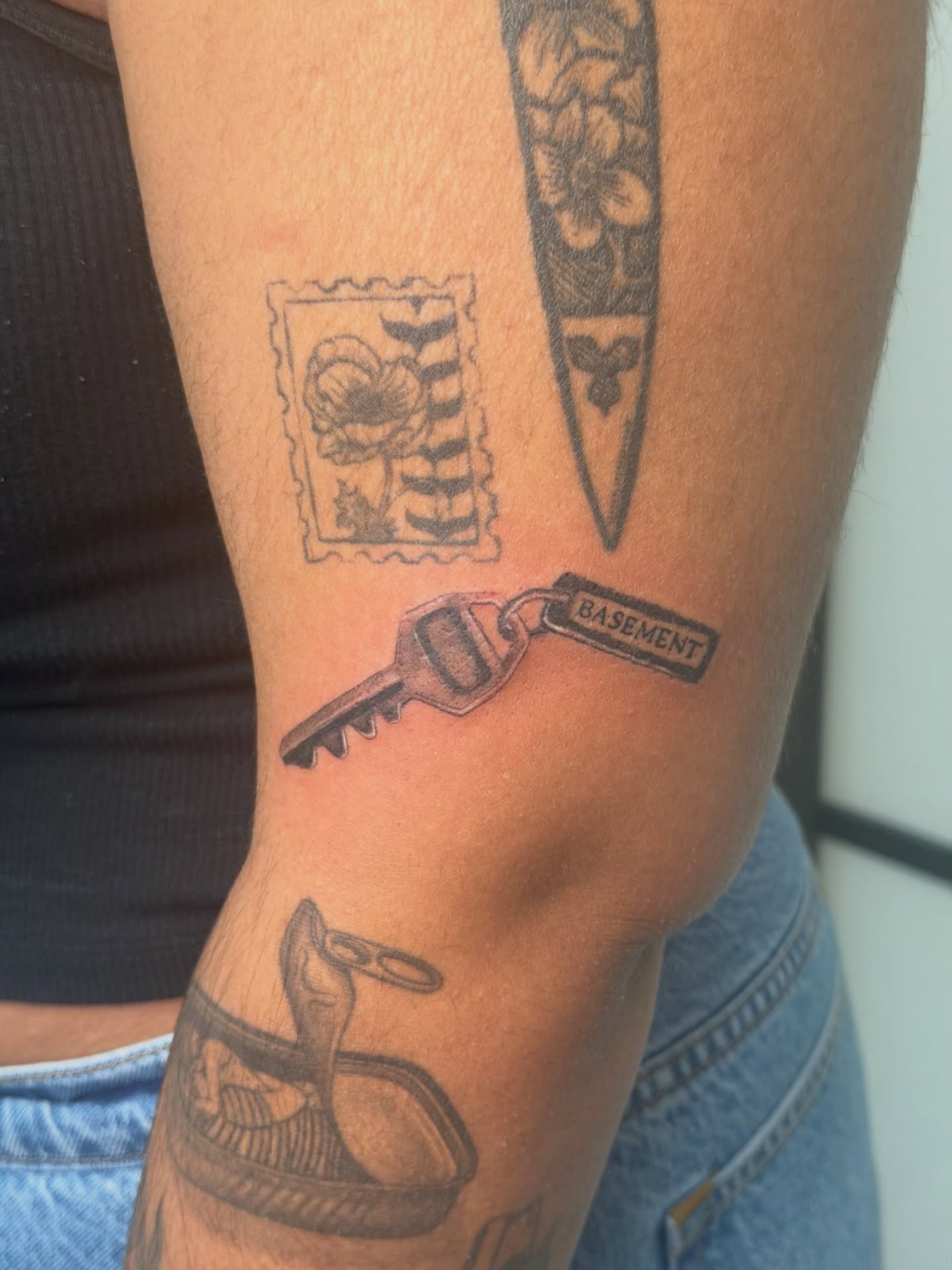 Key with 'basement' text black and grey tattoo on the forearm by Alaska