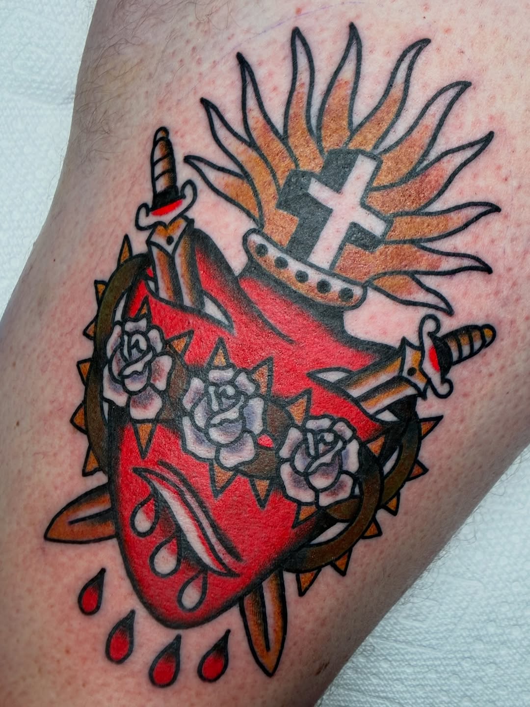 Sacred heart with swords and roses American traditional tattoo on the thigh by Sav Robinson