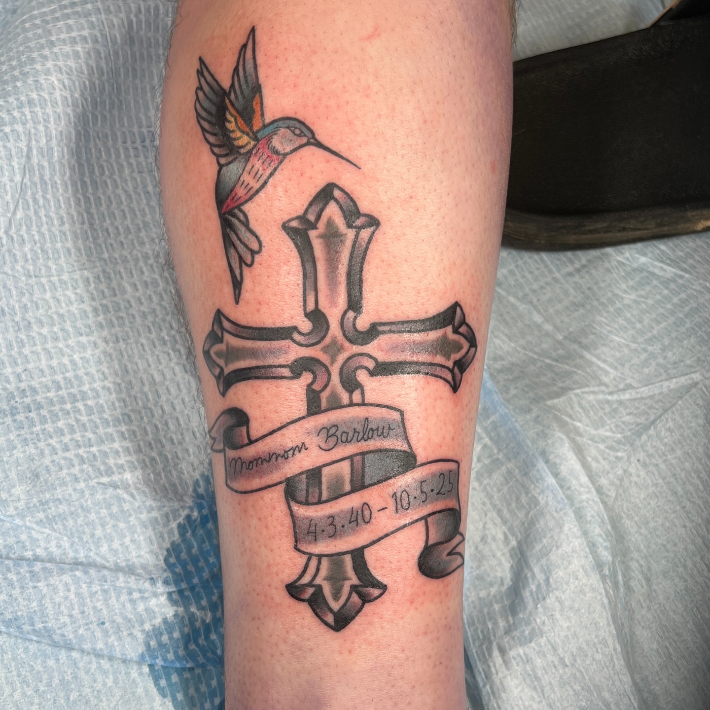 Cross with hummingbird American traditional tattoo on the forearm by Brian Mock