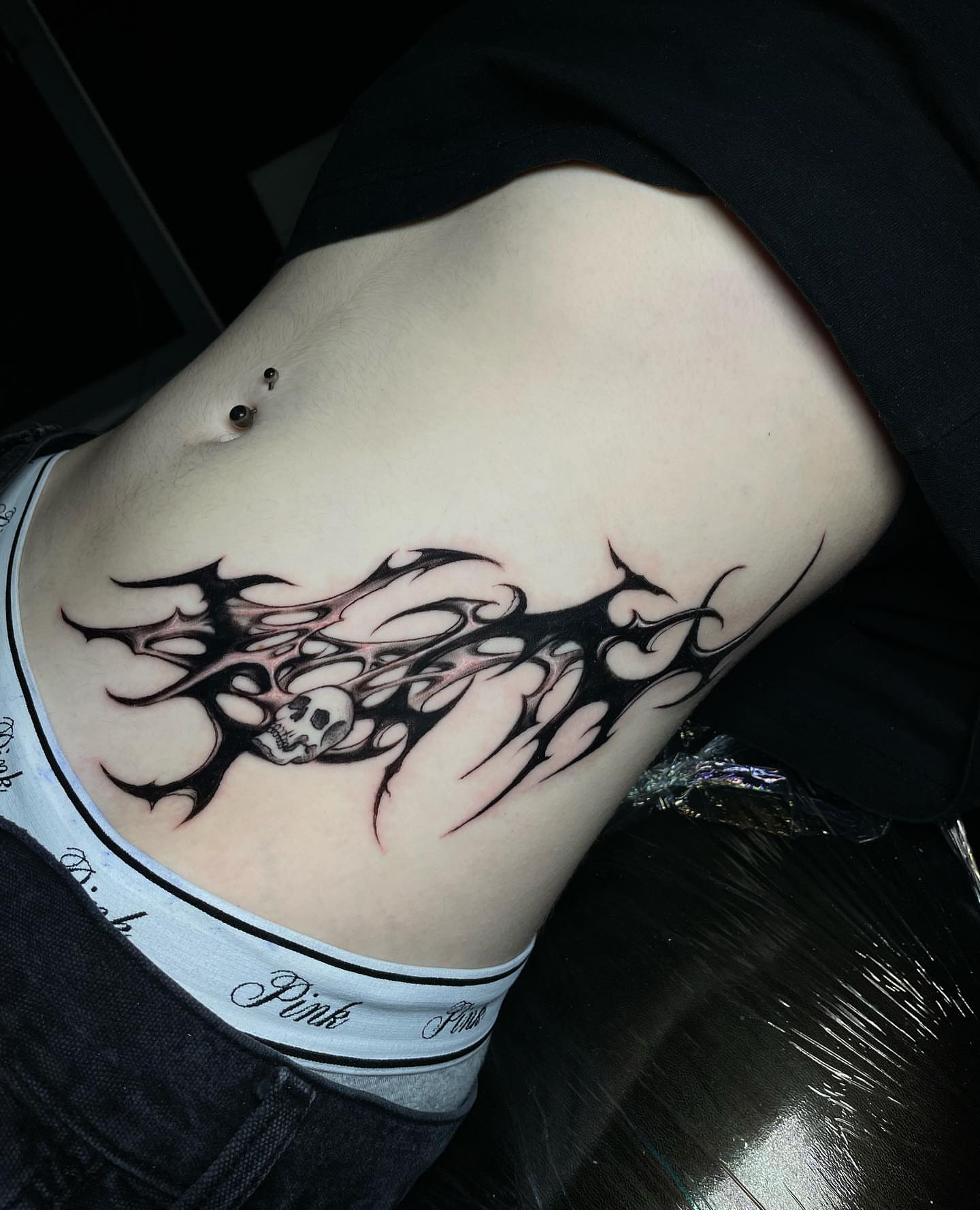 Skull and tribal design tribal tattoo on the ribs by Nikko