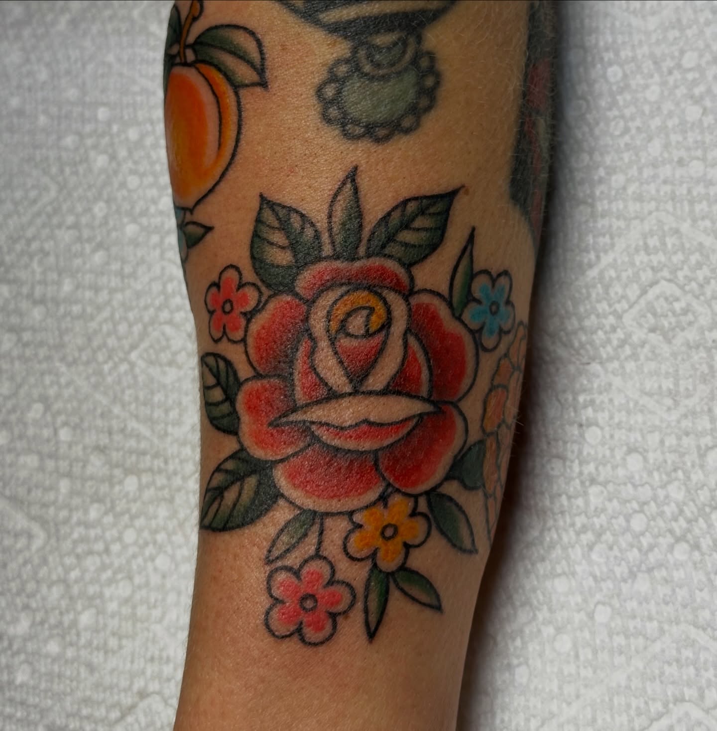 Rose and flowers American traditional tattoo on the forearm by Lauren DeLizza