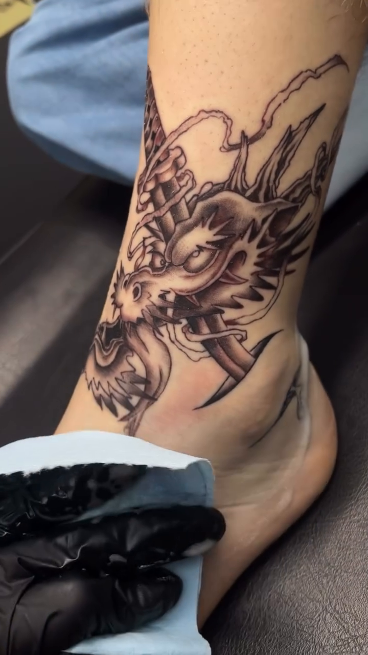Dragon head with sword Japanese tattoo on the leg by ꧁༺𝔅𝔦𝔤 ℭ𝔥𝔲𝔫𝔤𝔲𝔷༻꧂, San Diego, California