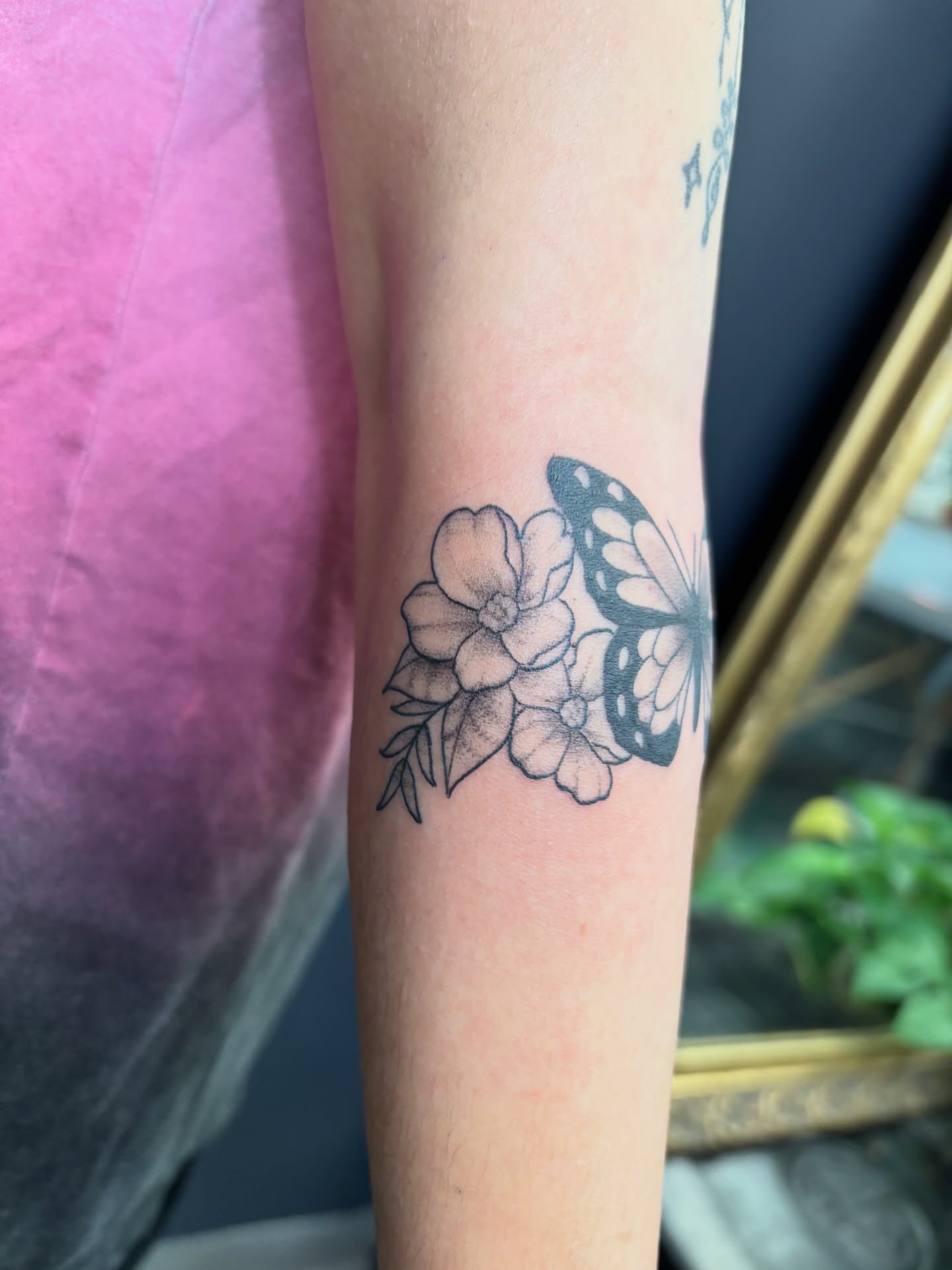 Flowers and butterfly black and grey tattoo on the forearm by Noah Blum