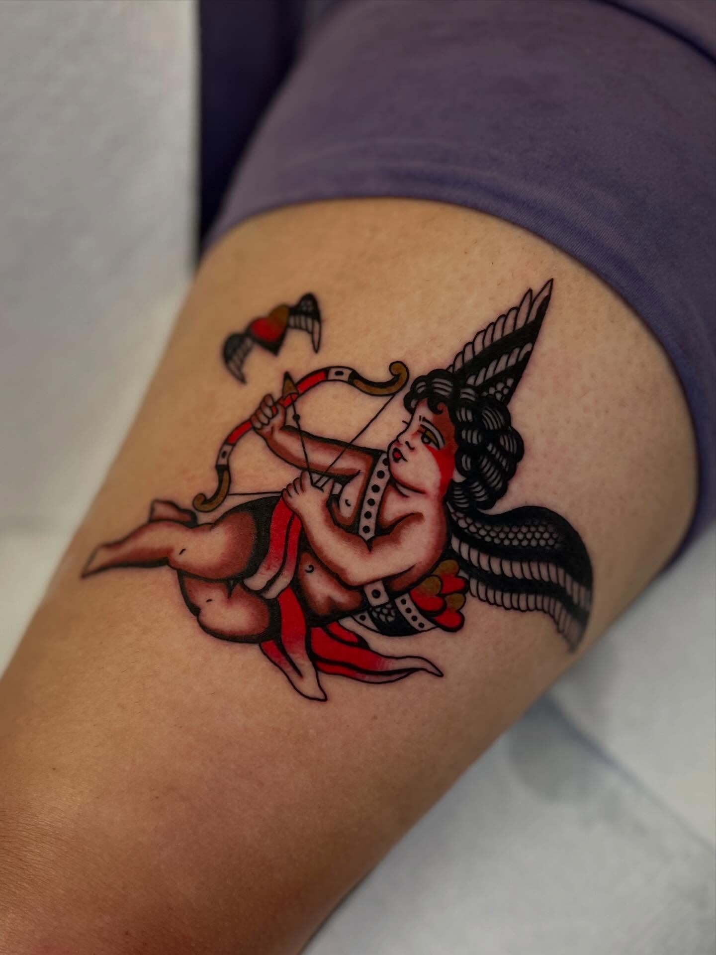 Angel with bow and arrow American traditional tattoo on the thigh by Syd Sayyah