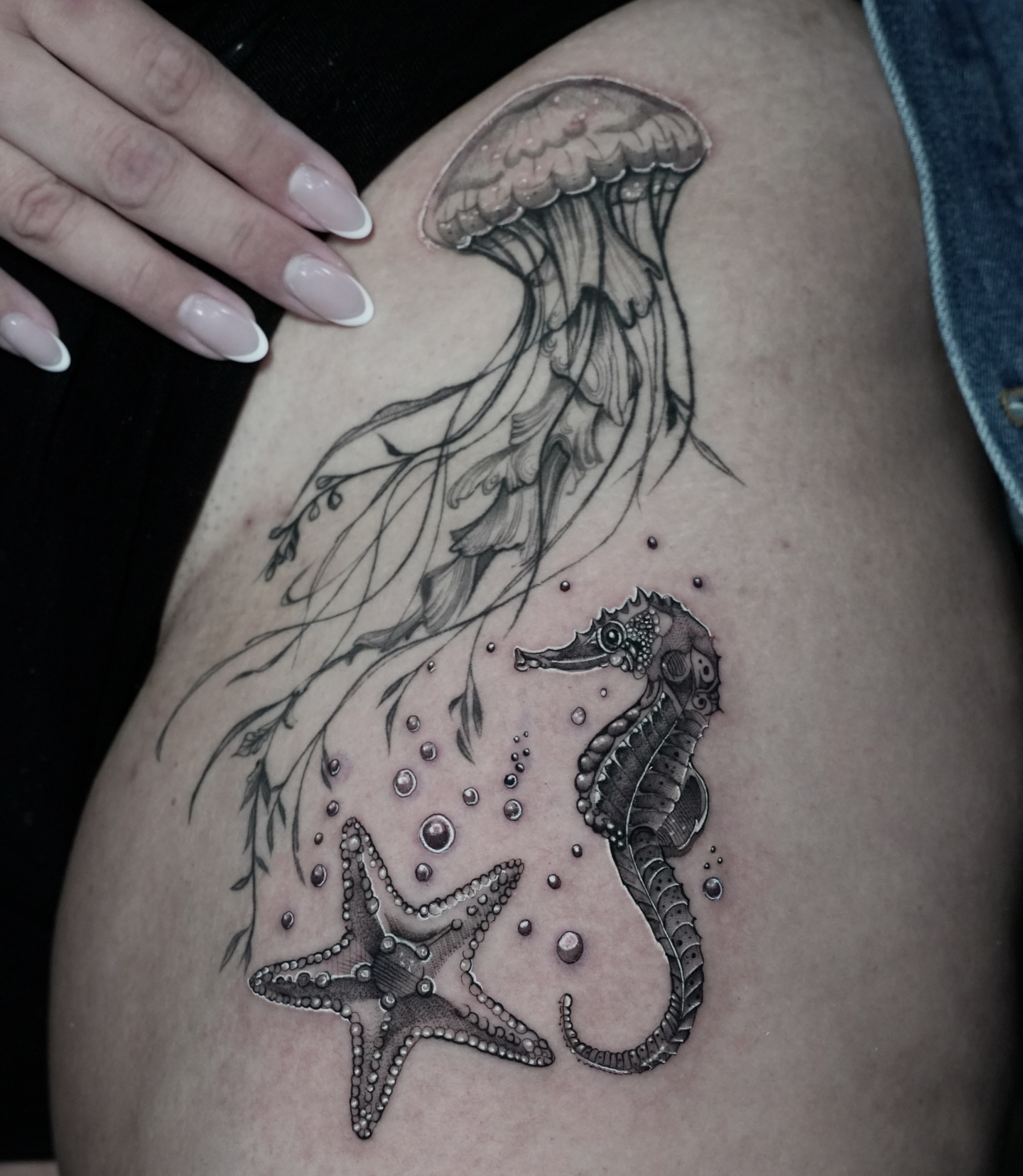 Jellyfish, seahorse, starfish dotwork tattoo on the thigh by Alejo Ibanez Tattoo
