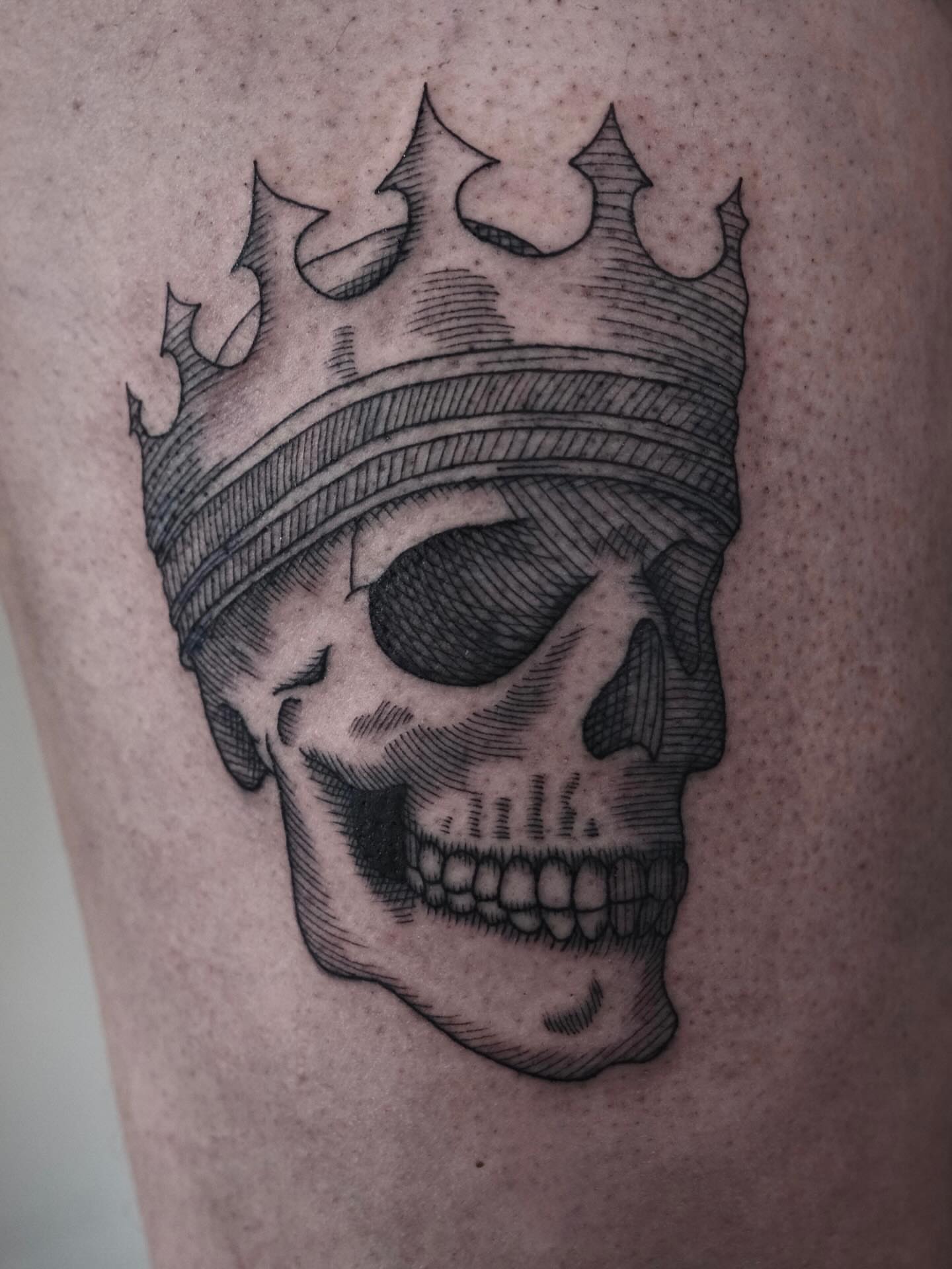 Skull wearing crown black and grey tattoo on the thigh by Peter(피터)