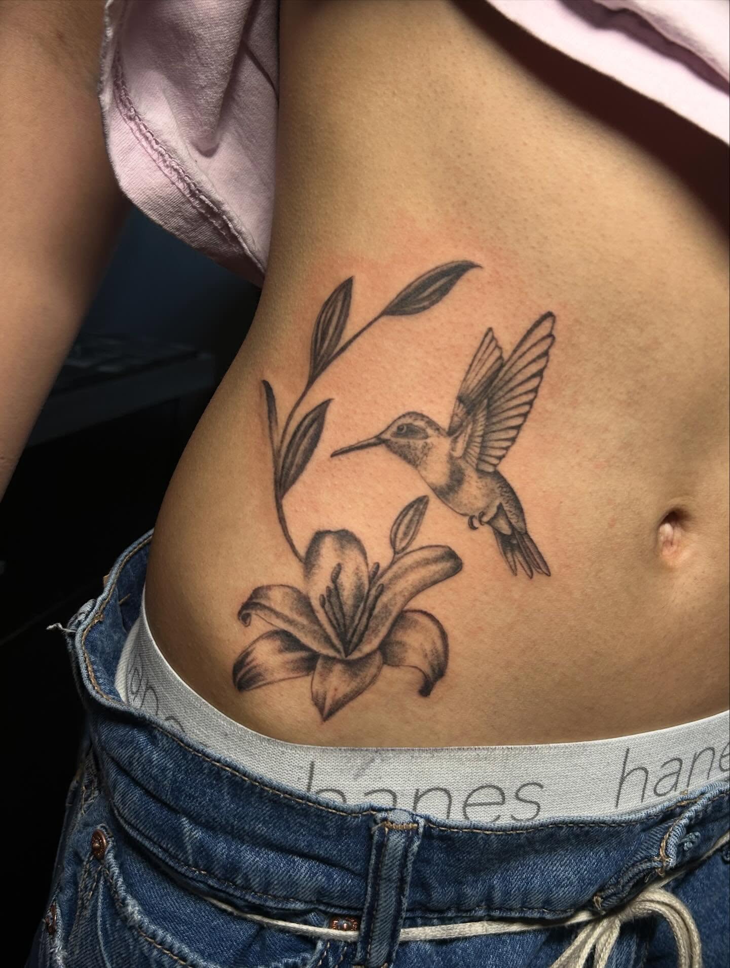 Hummingbird and lily realism tattoo on the ribs by Ximena Favela