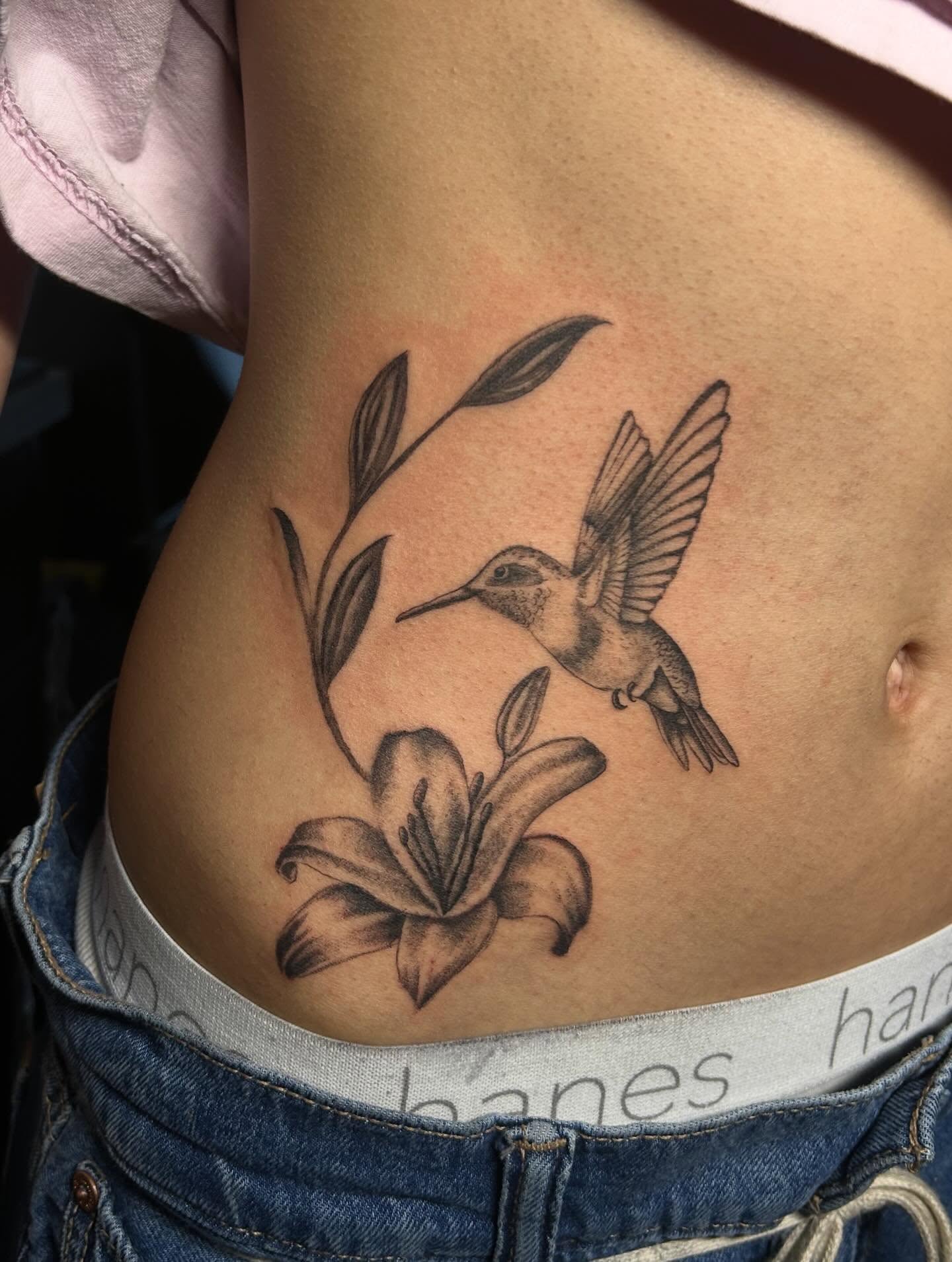 Hummingbird and lily realism tattoo on the ribs by Ximena Favela
