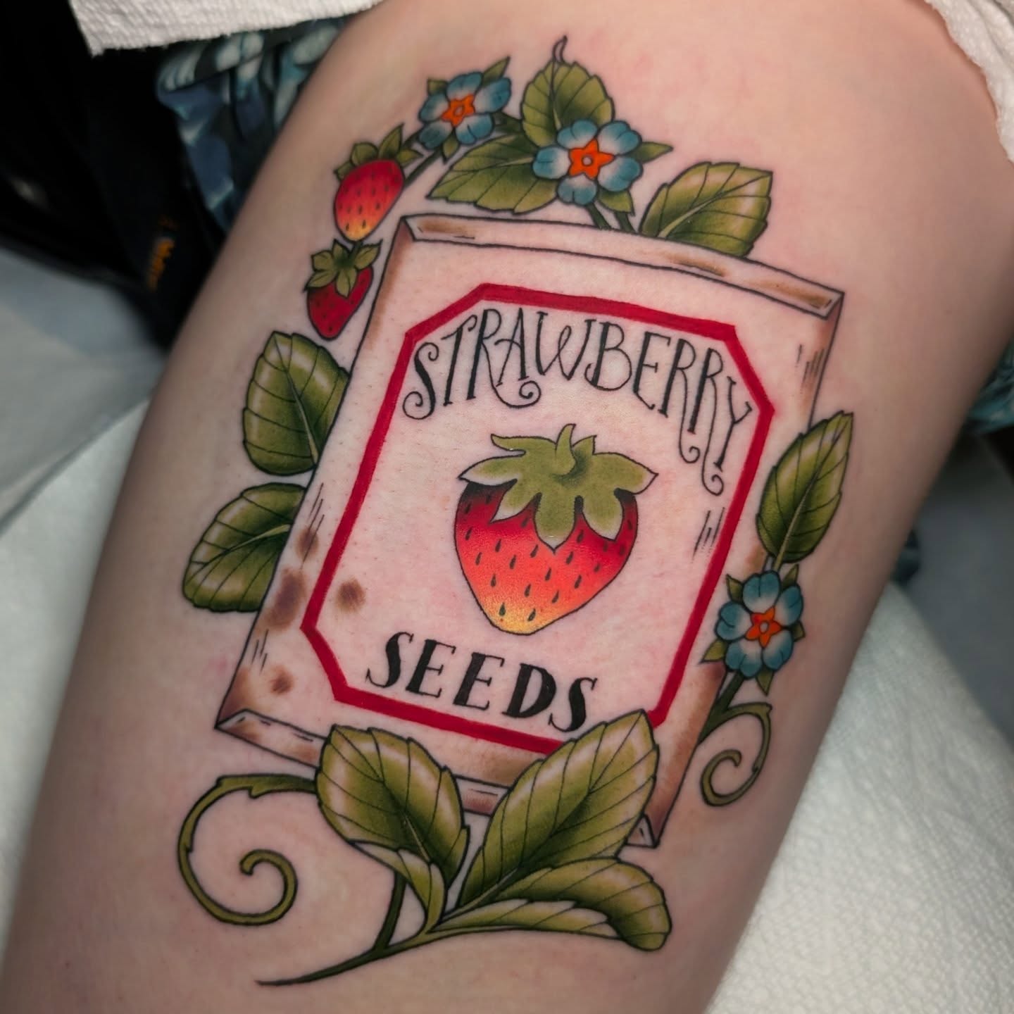 Strawberry seeds American traditional tattoo on the thigh by Ellie