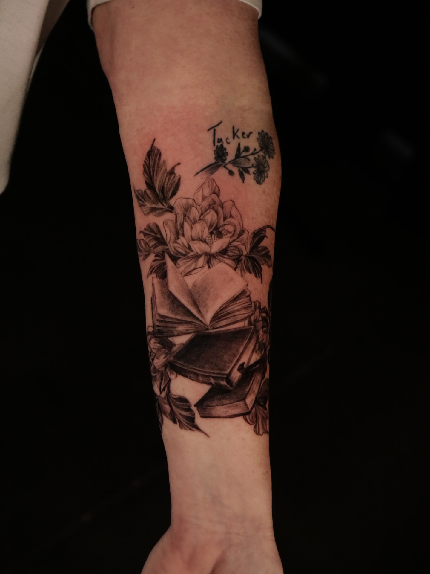 Book and flowers realism tattoo on the forearm by Sloppy