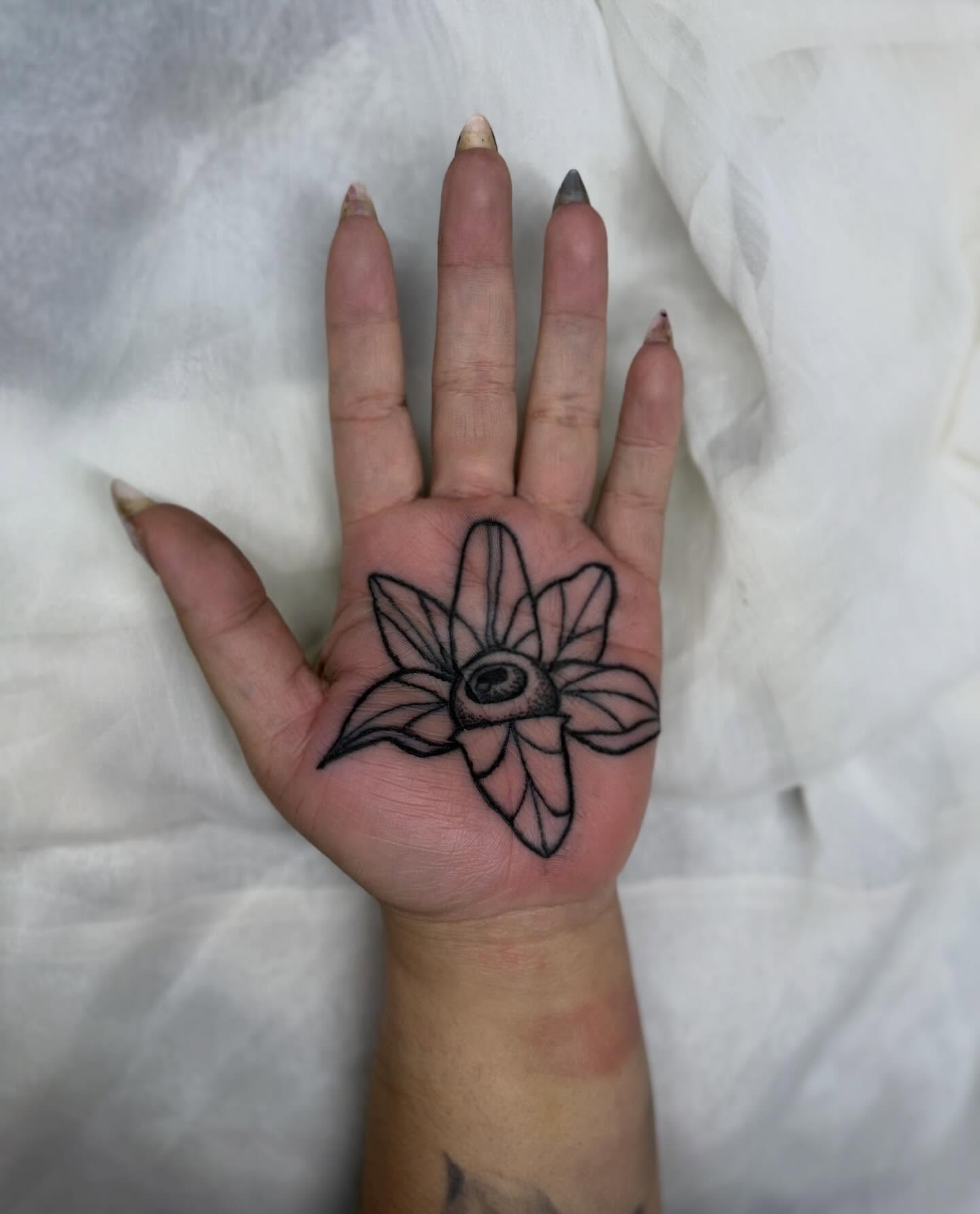 Flower black and grey tattoo on the hand by Sasha “Sashimi” Shabasov