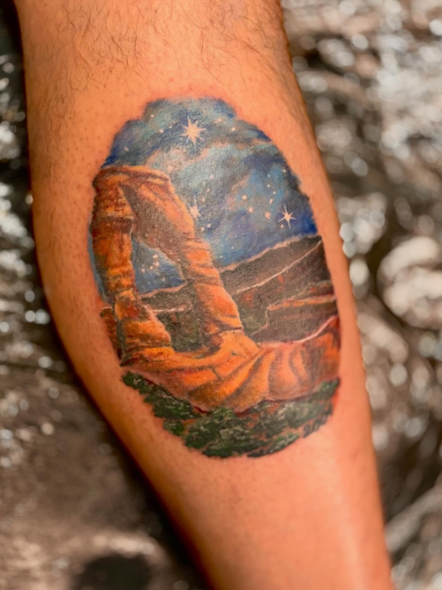 Landscape with arch realism tattoo on the forearm by Taylor Tha Color Queen