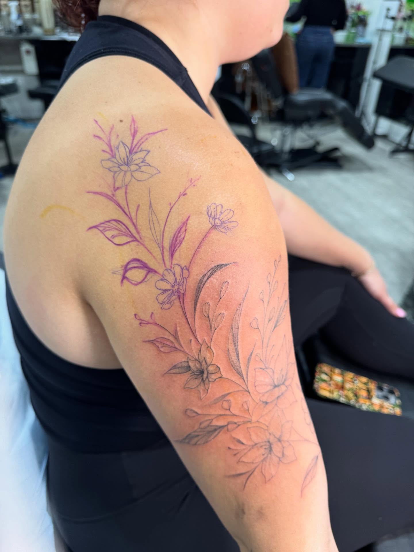 Floral bouquet fine line tattoo on the upper arm by Danae Andino