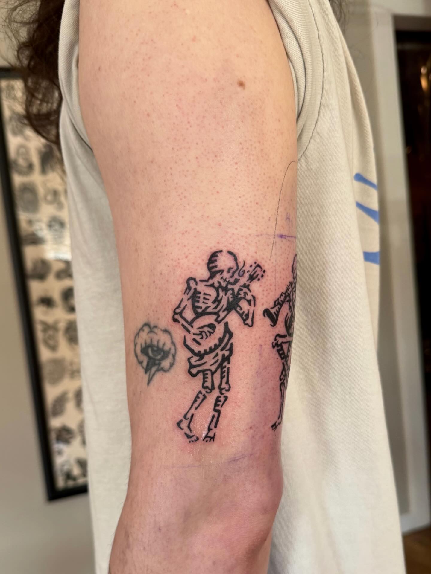 Skeleton playing guitar black and grey tattoo on the forearm by M