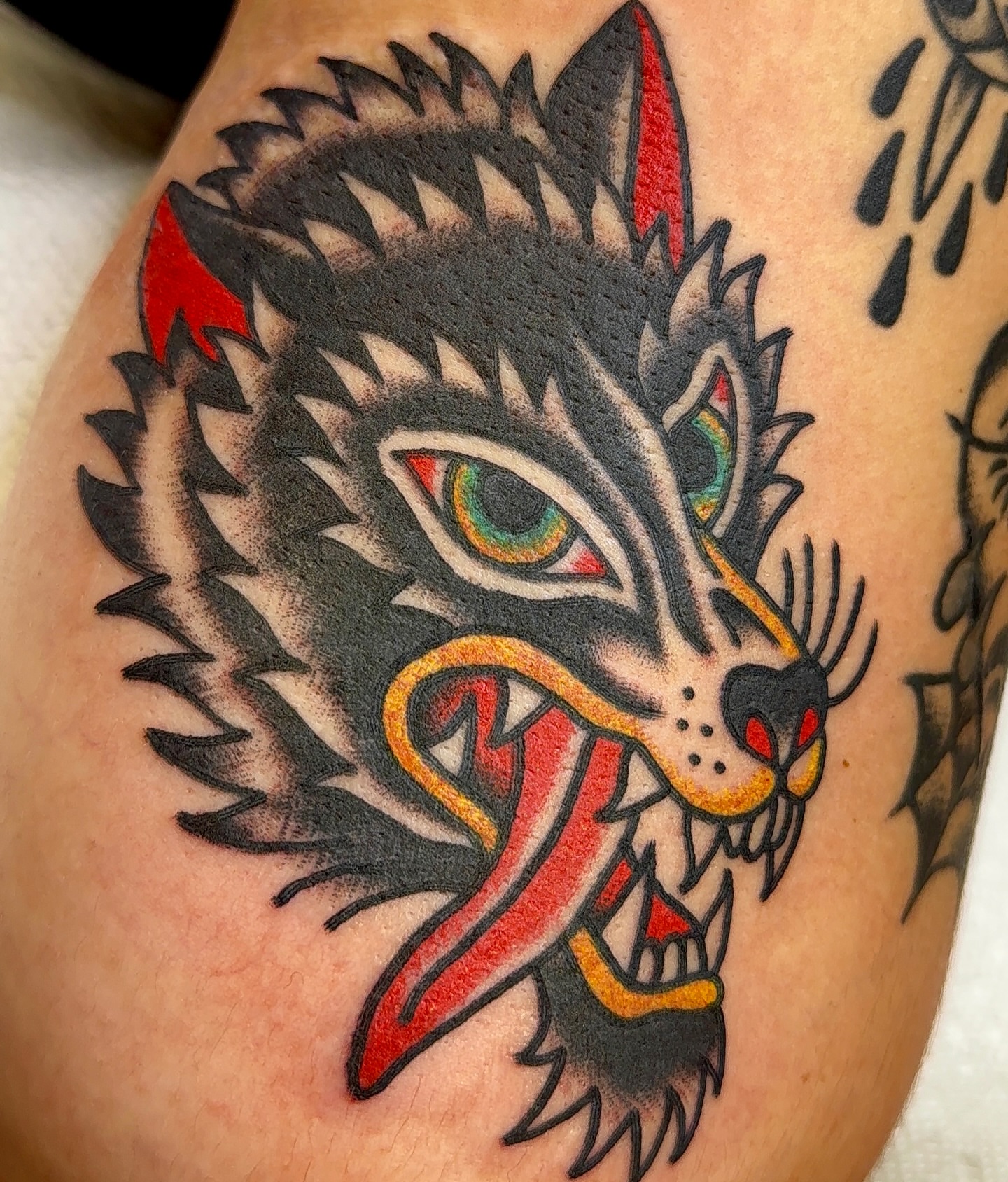 Wolf American traditional tattoo on the upper arm by VAY