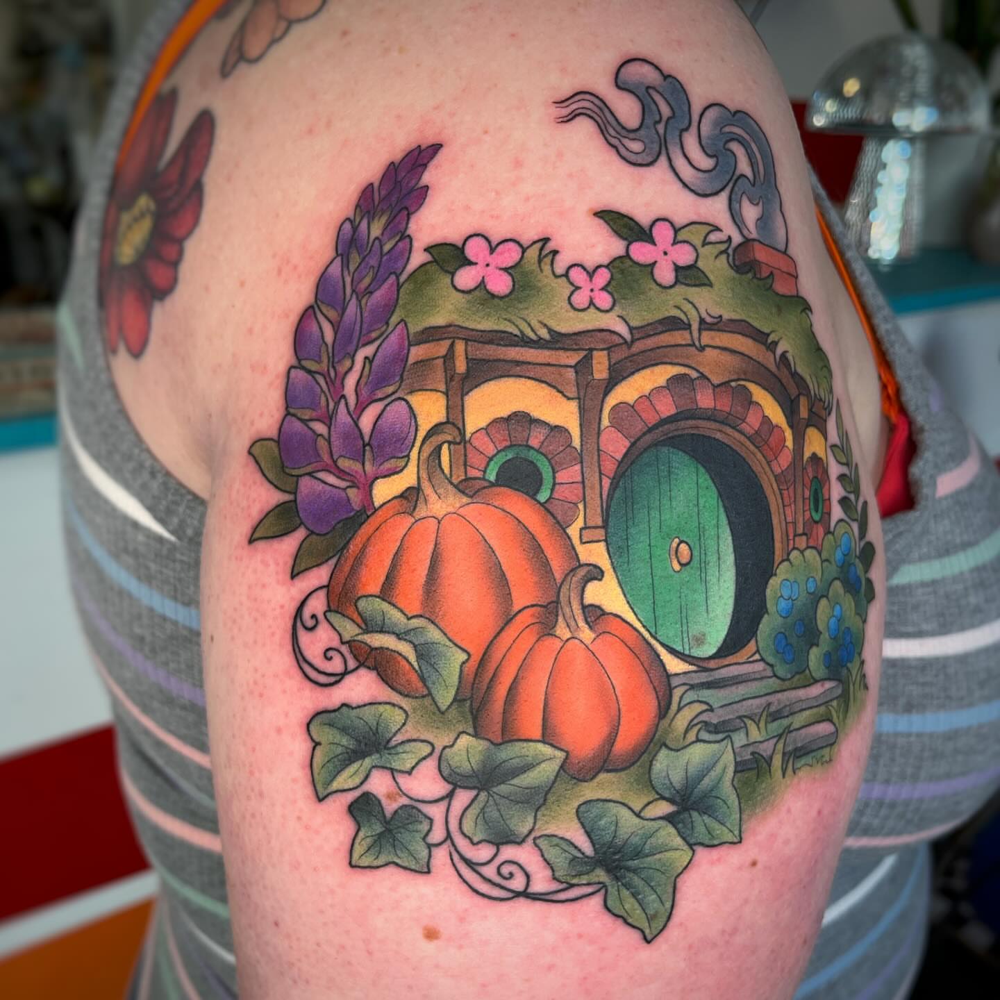 Hobbit house with pumpkins new school tattoo on the shoulder by Emi Collison