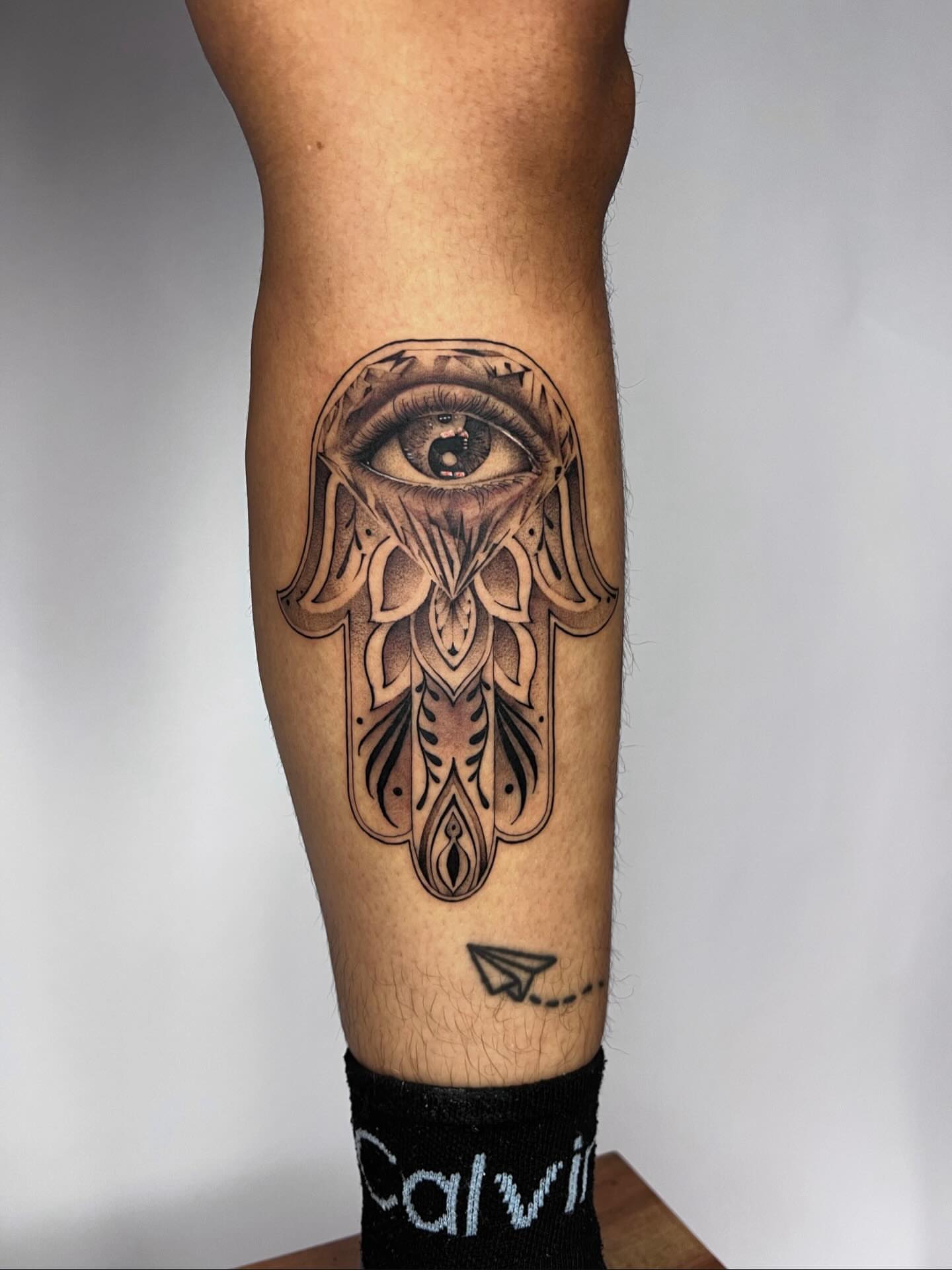 Eye with hamsa geometric tattoo on the forearm by Dolph.