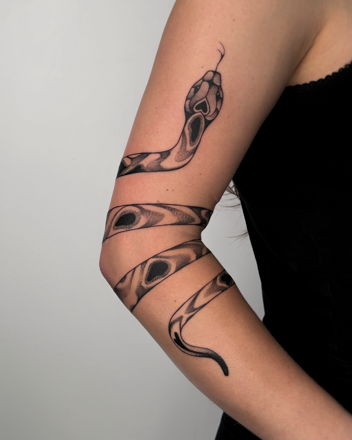 Snake dotwork tattoo on the forearm by Kuya, Berkeley, California