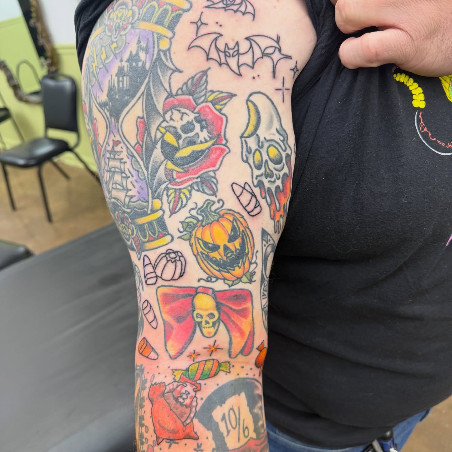Halloween-themed motifs American traditional tattoo on the forearm by autumn sky