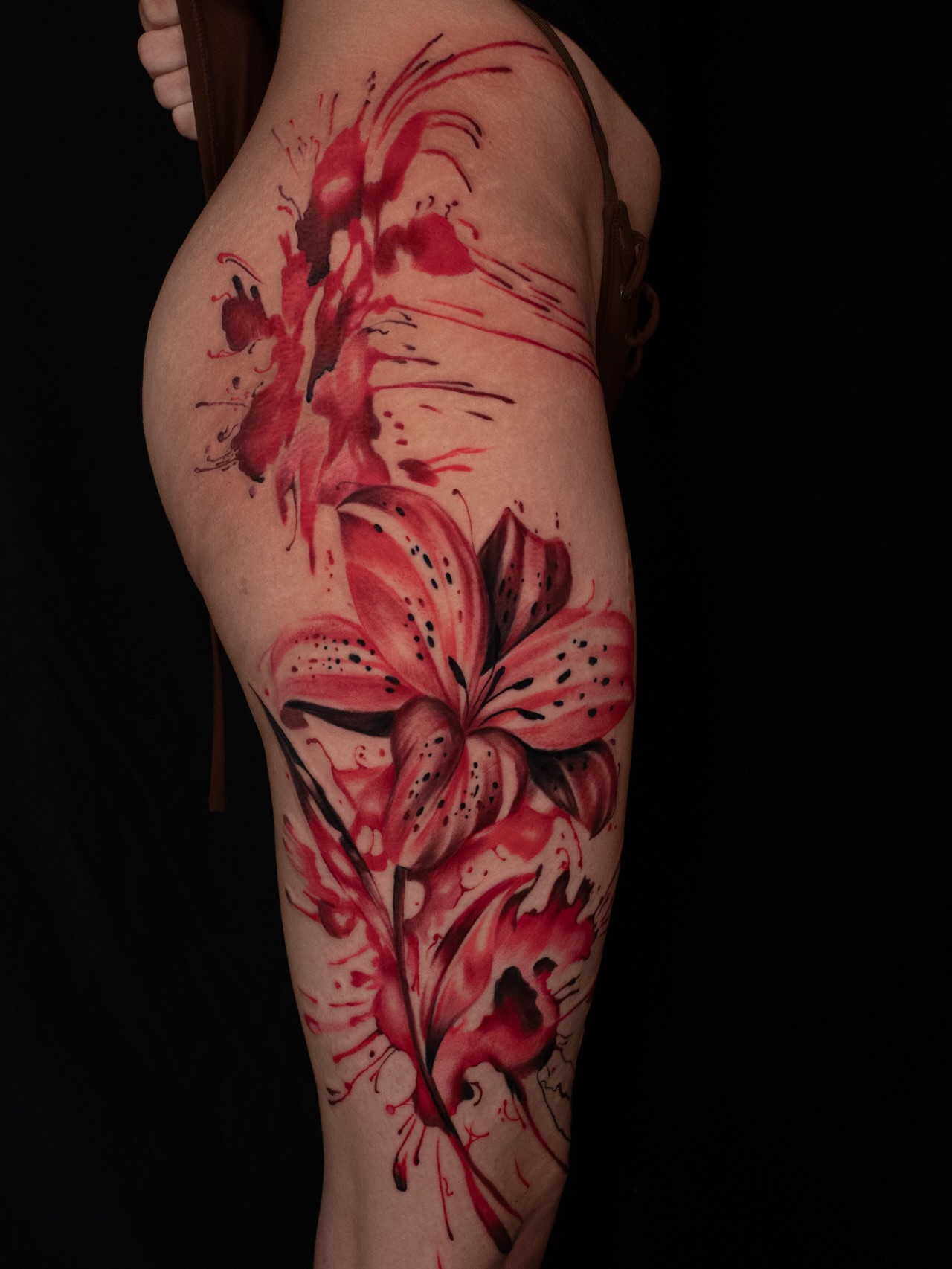 Lily watercolor tattoo on the thigh by Raul Ortiz