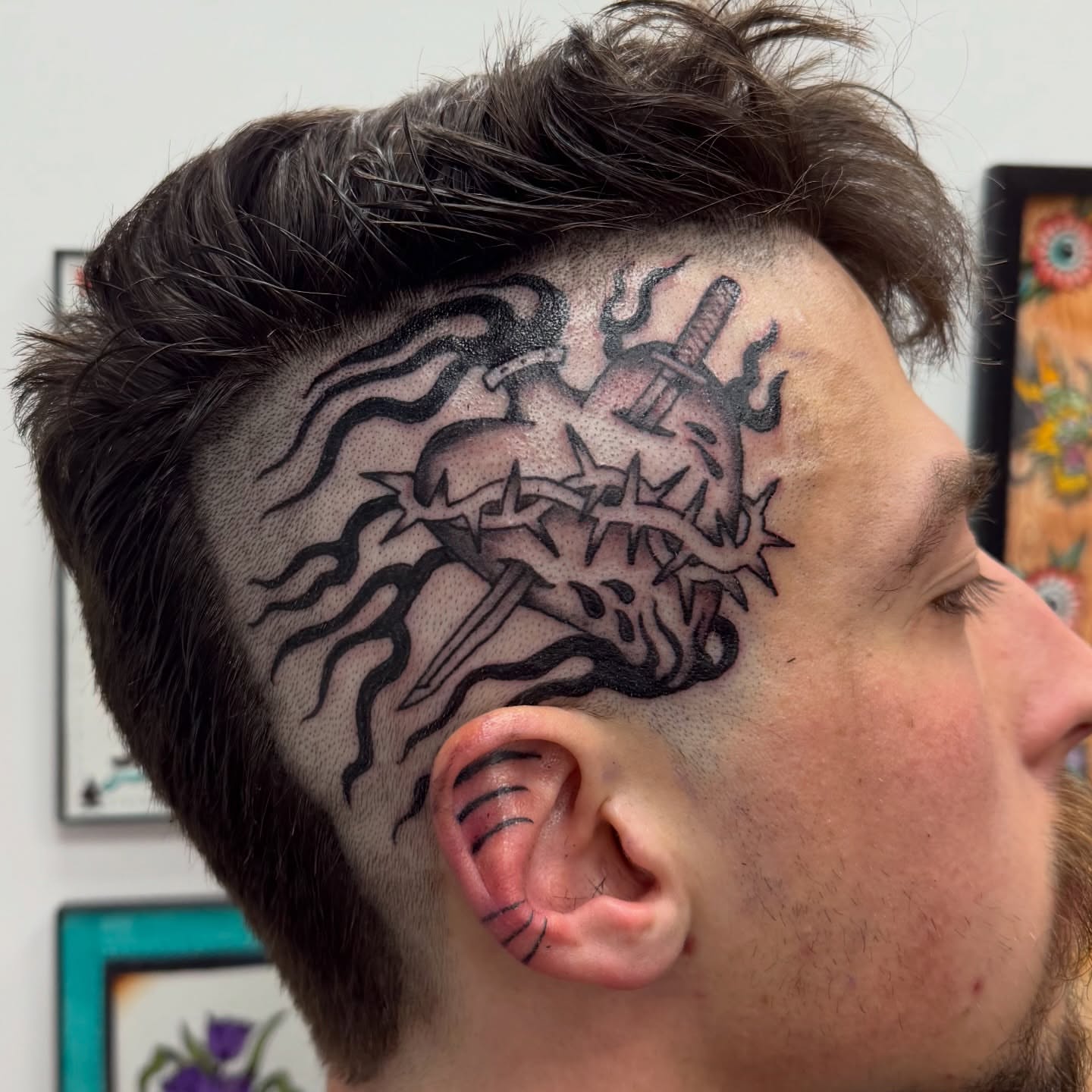 Heart with sword black and grey tattoo on the head by c☮︎urt