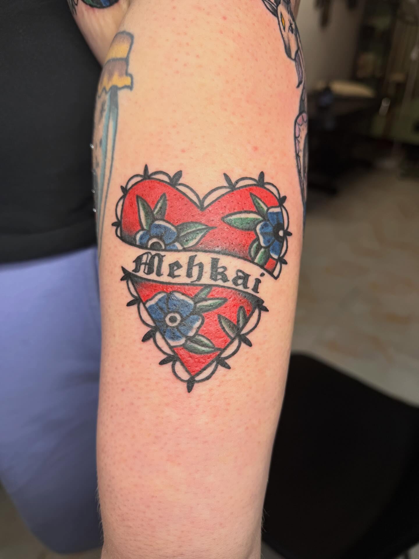 Heart with name American traditional tattoo on the forearm by Abby