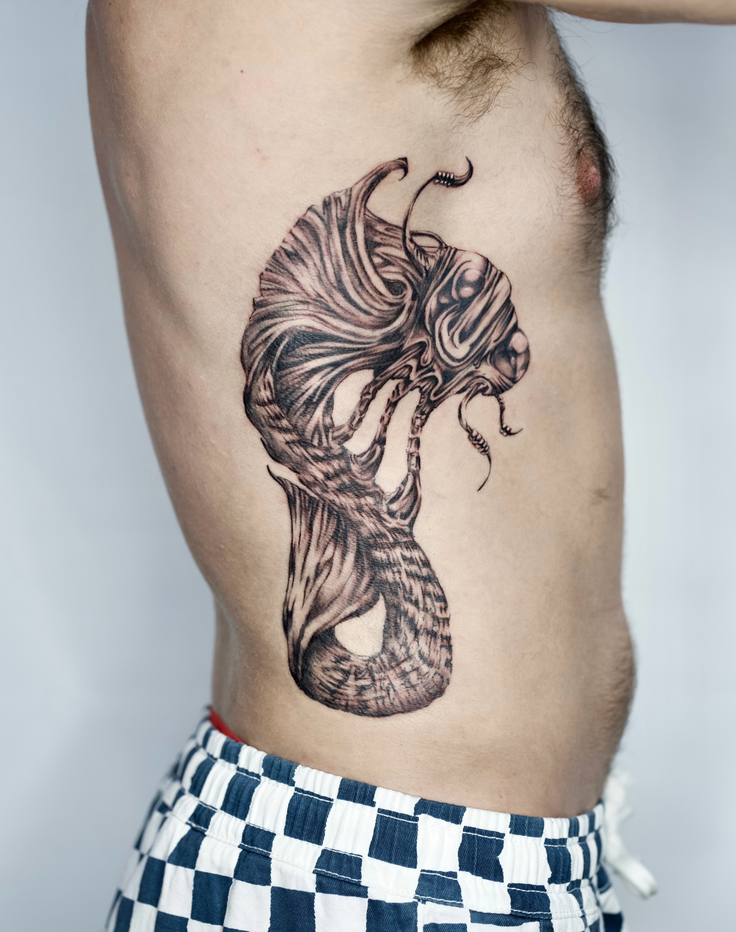 Abstract creature surrealism tattoo on the torso by Lauren ๐