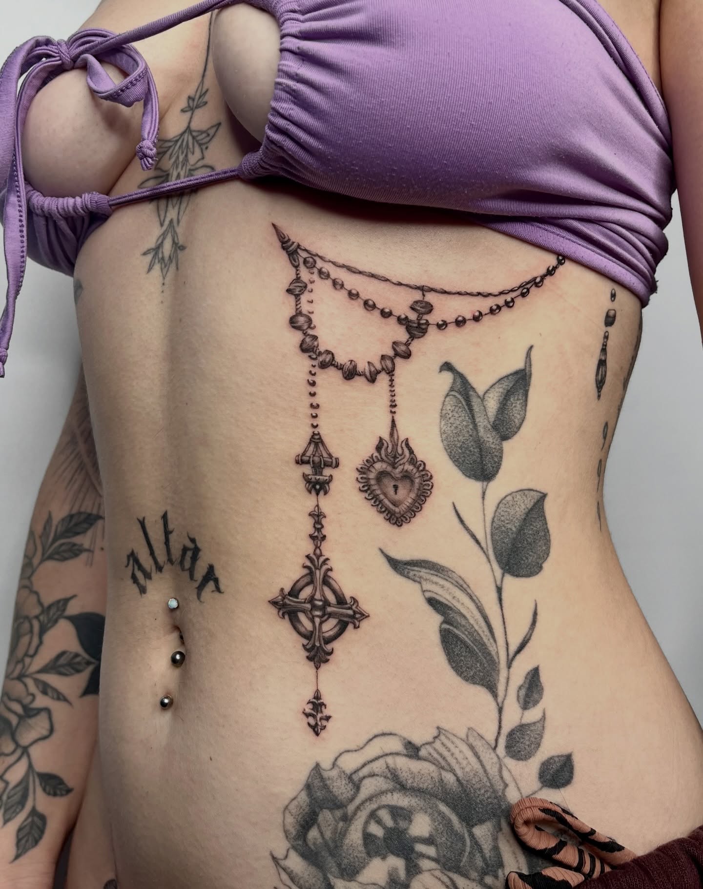 Religious rosary black and grey tattoo on the ribs by Lauren ๐