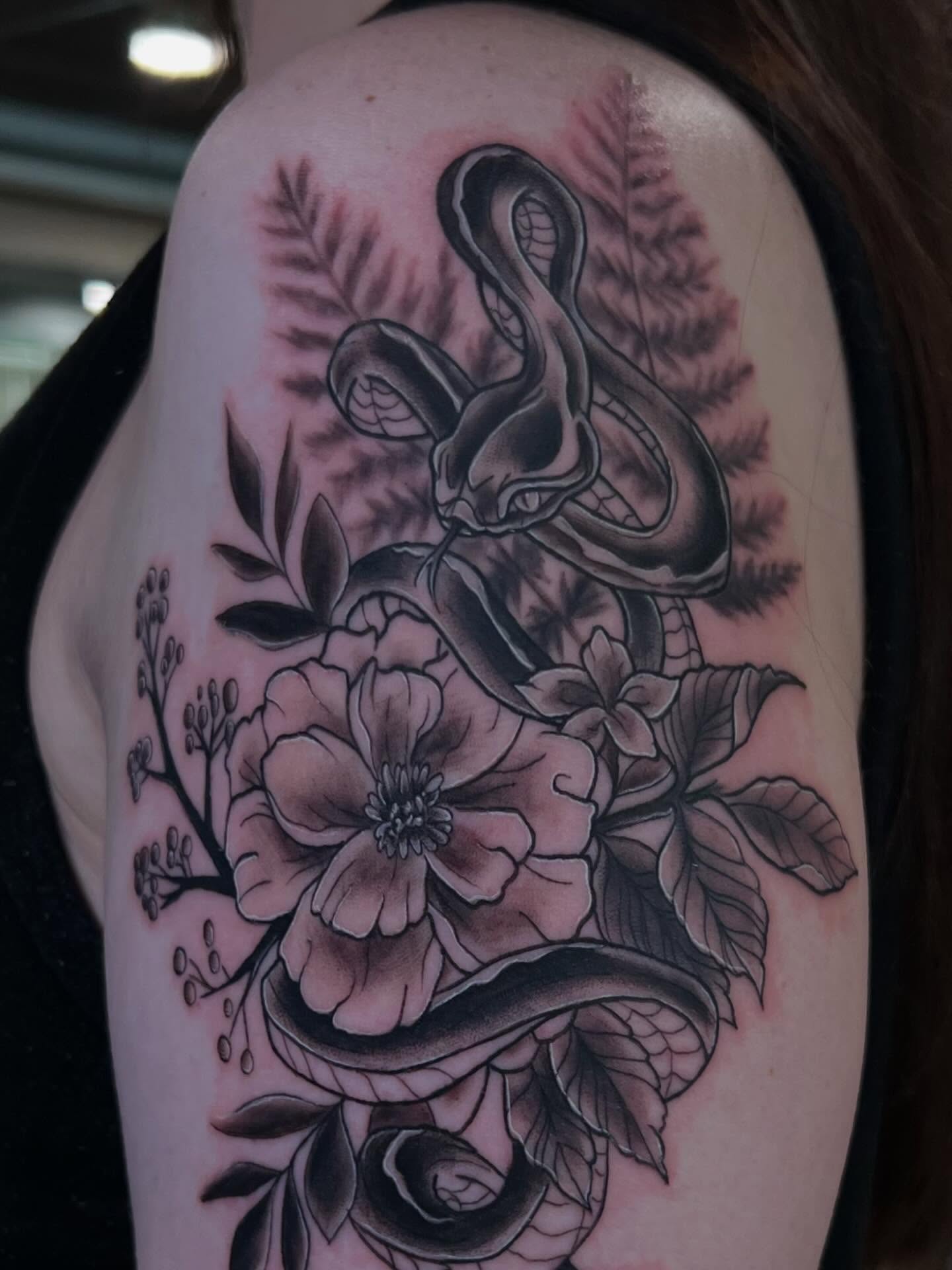 Snake and flowers realism tattoo on the shoulder by Jessica Kloos