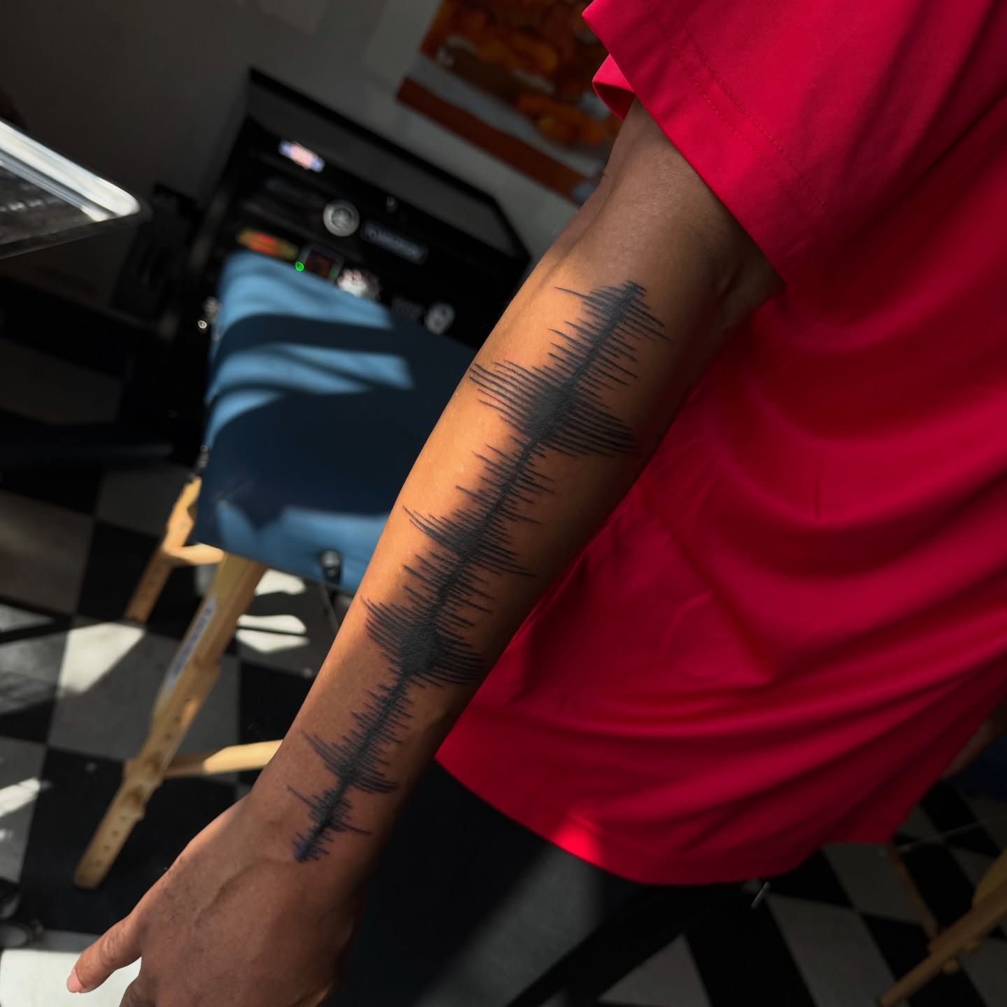 Sound wave black and grey tattoo on the upper arm by Nina Nichole