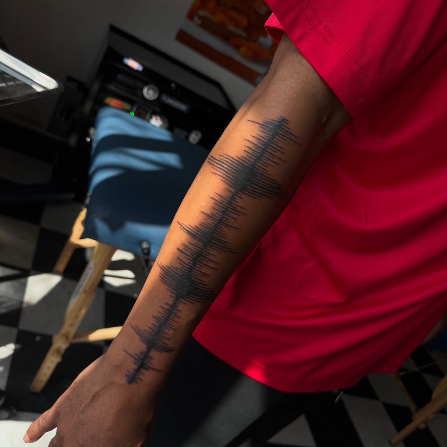 Sound wave black and grey tattoo on the upper arm by Nina Nichole