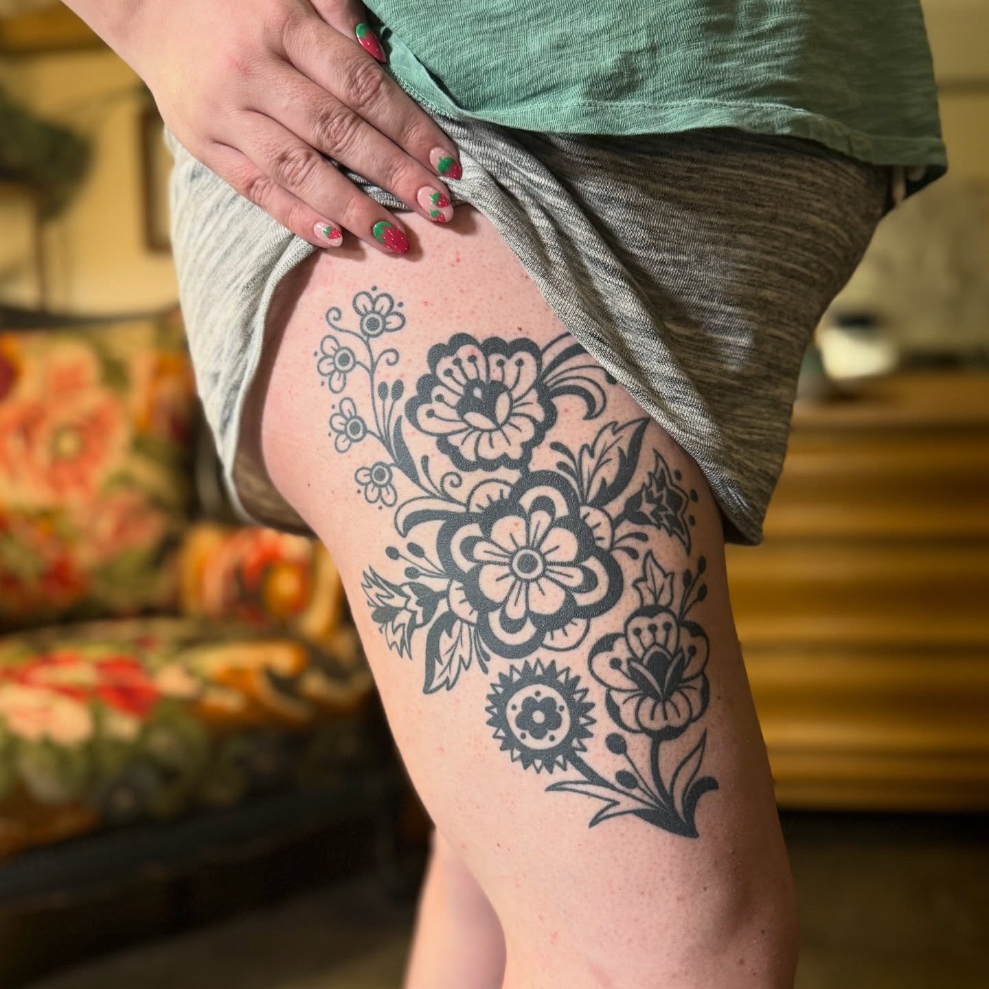Floral bouquet black and grey tattoo on the thigh by Leah - Tattoo Artist