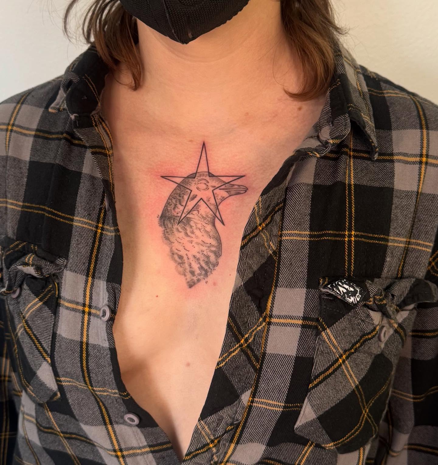 Bird within star black and grey tattoo on the chest by Ivy