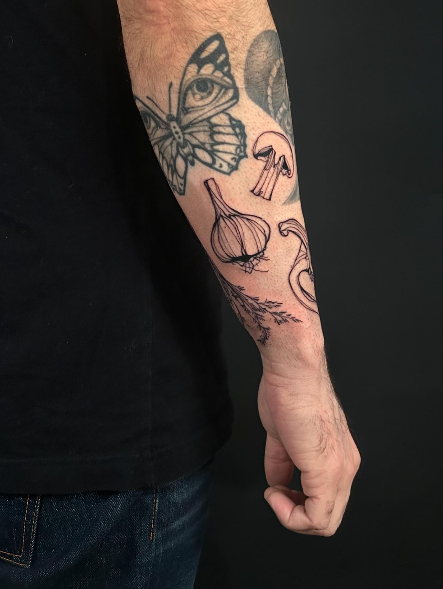 Butterfly, garlic, eye black and grey tattoo on the forearm by @laurabochet_tattoo, Beacon, NY