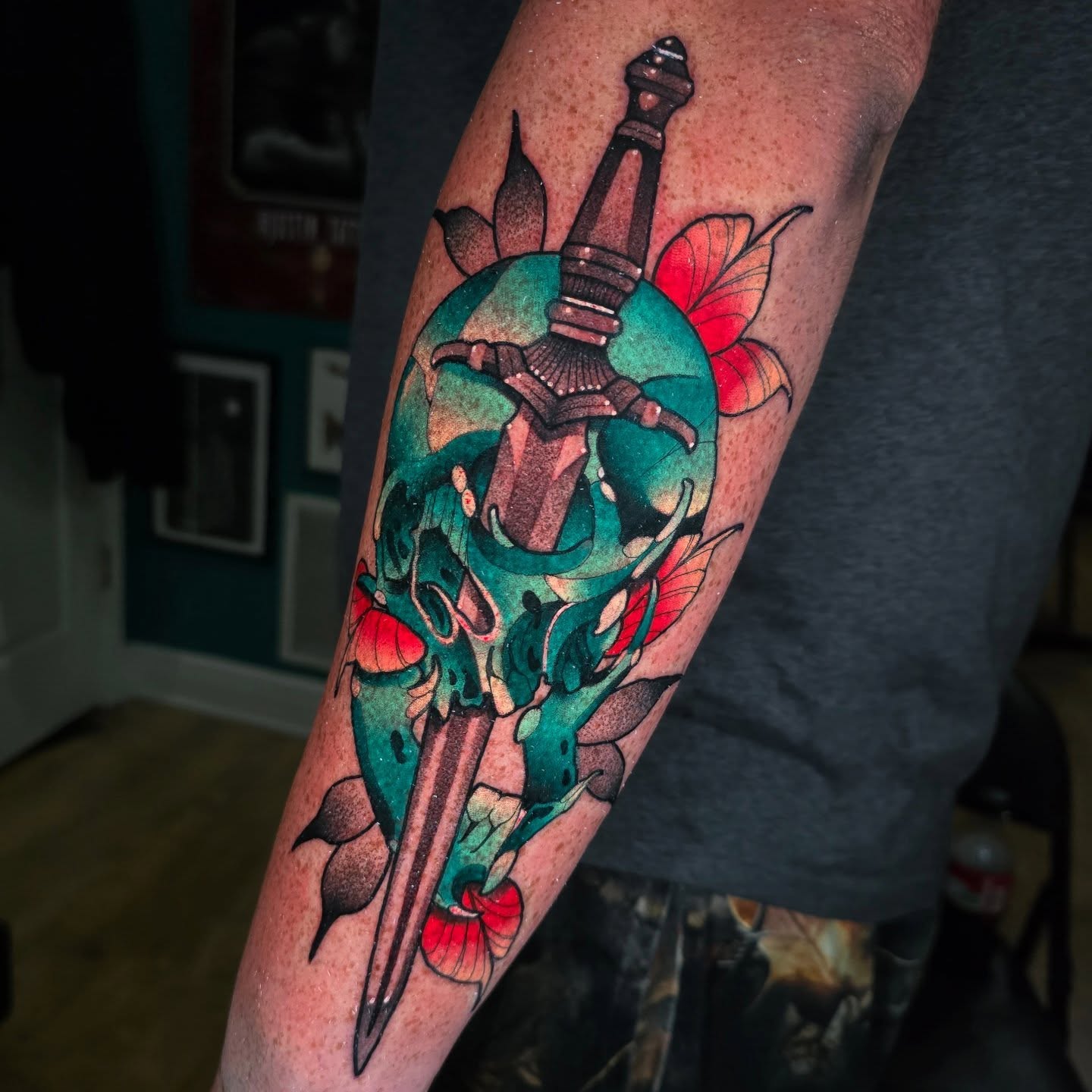Skull with sword neo-traditional tattoo on the forearm by Justin Eldridge