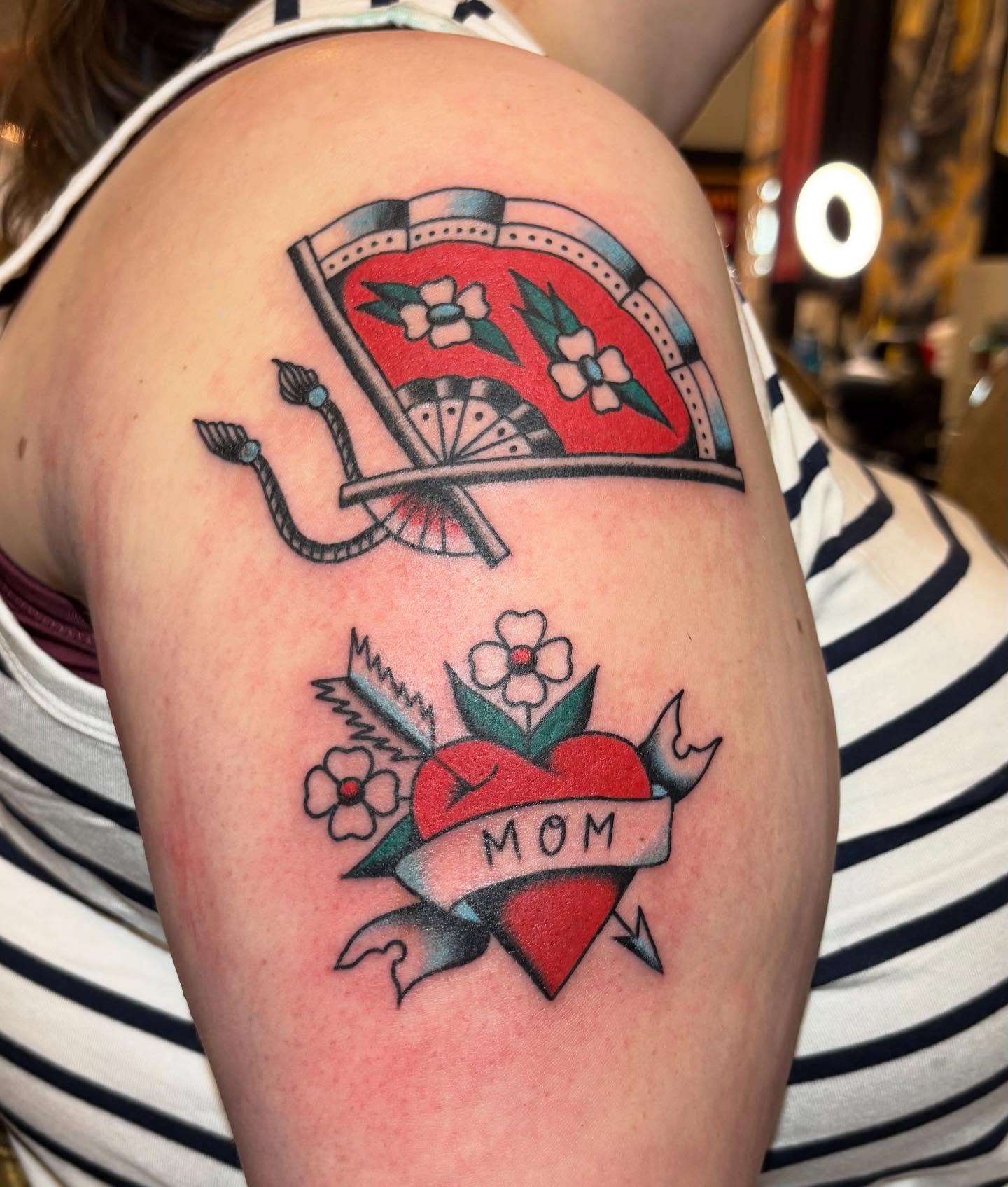 Heart with flowers American traditional tattoo on the shoulder by Izzy