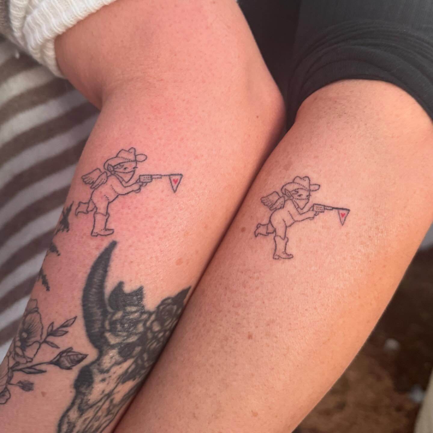 Cowboy cherub black and grey tattoo on the forearm by springgreens