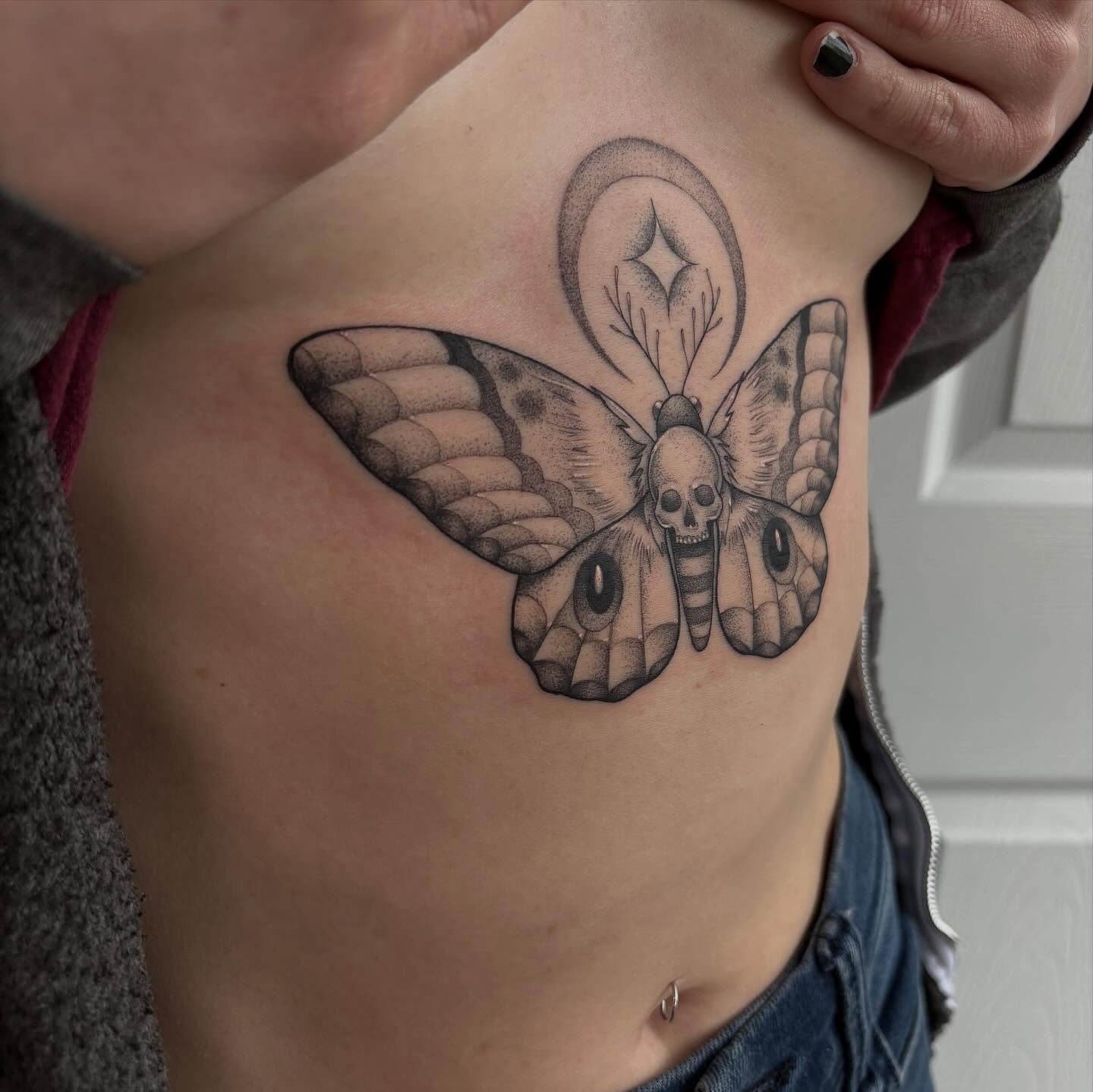Moth with skull head dotwork tattoo on the ribs by Hailey Nicole