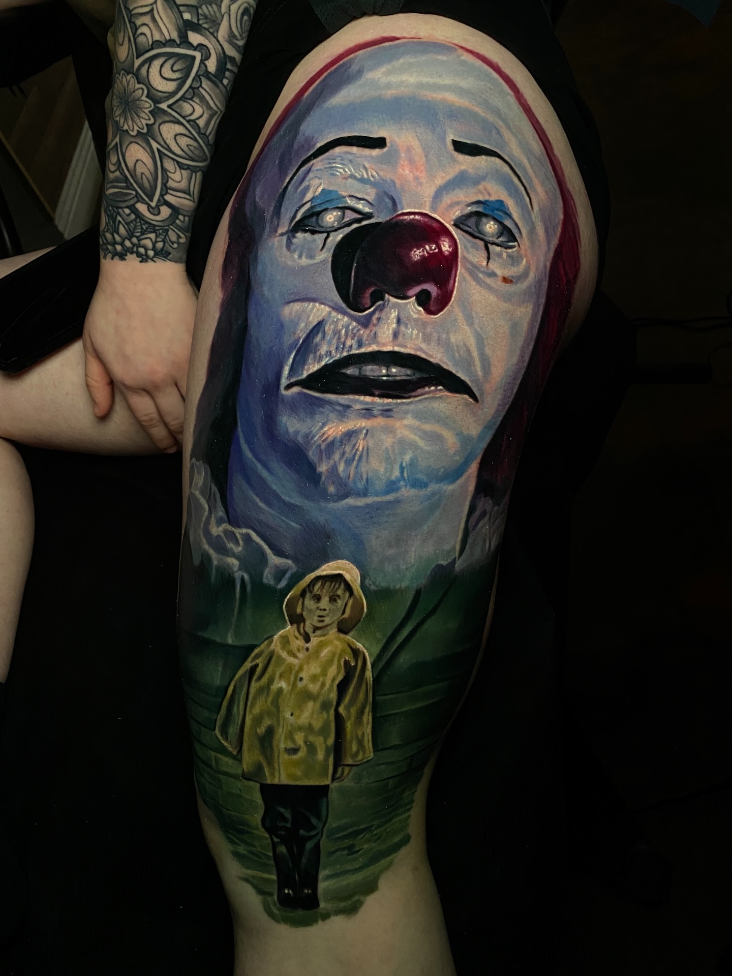 Clown and boy realism tattoo on the forearm by Dave James