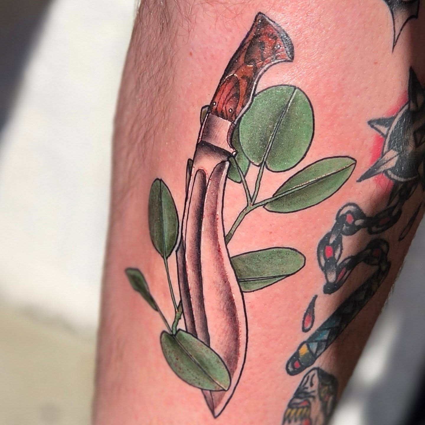 Knife and leaves American traditional tattoo on the forearm by Robert Glover