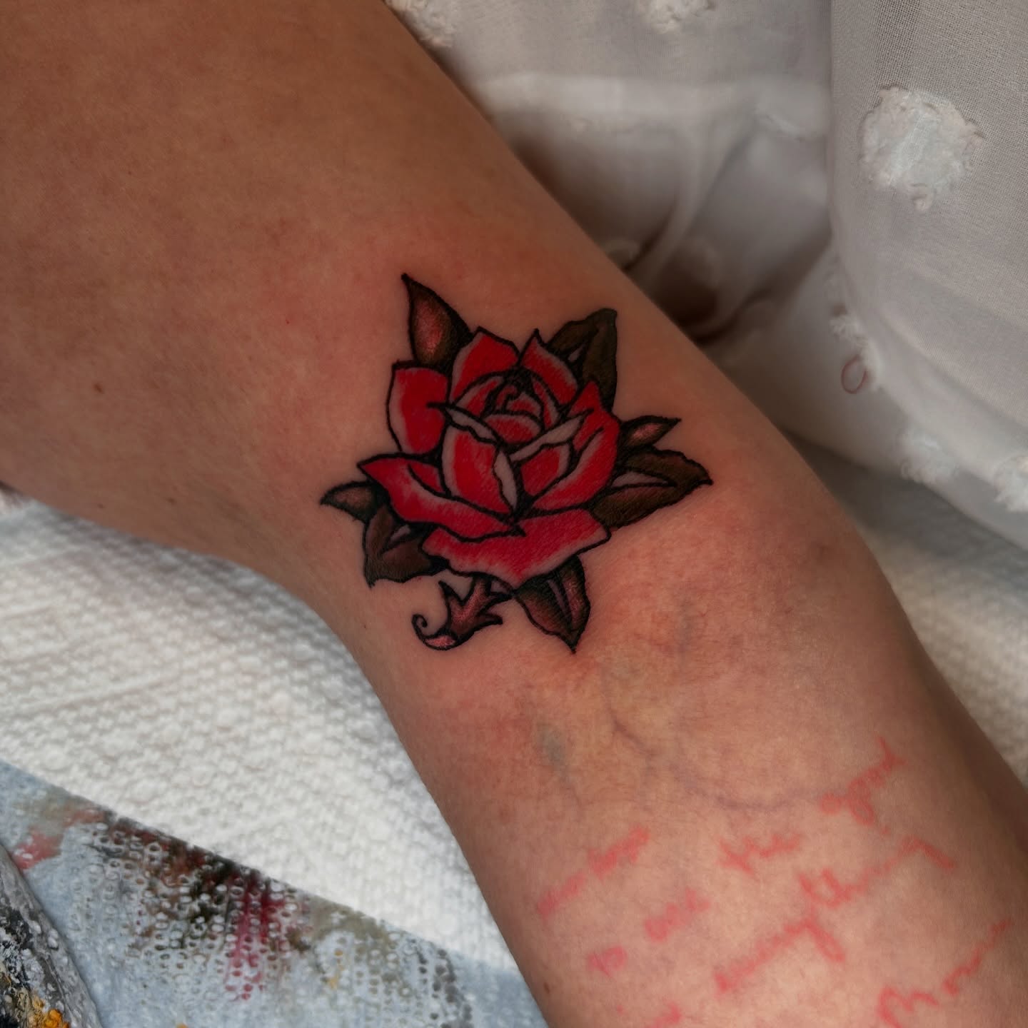 Red rose American traditional tattoo on the forearm by Kat McCoy Guidera, Nashville, Tennessee
