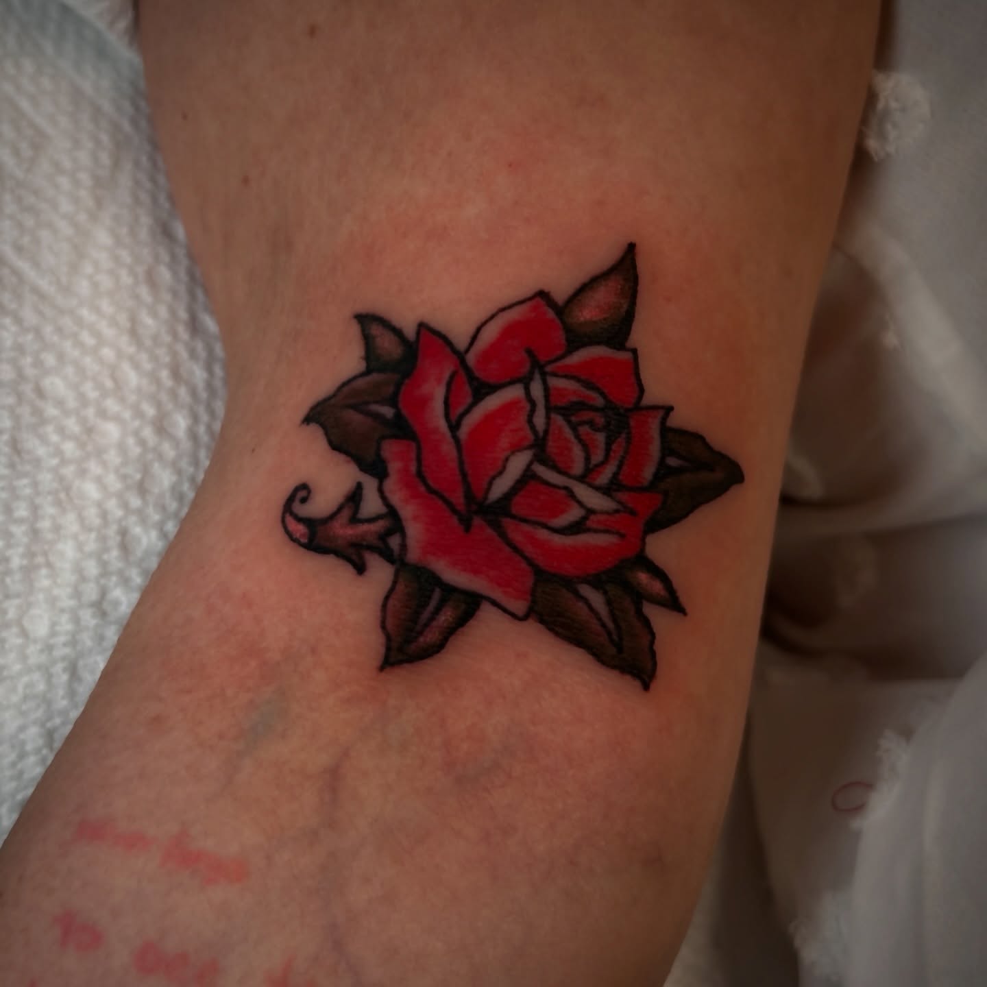 Red rose realism tattoo on the forearm by Kat McCoy Guidera, Nashville, Tennessee