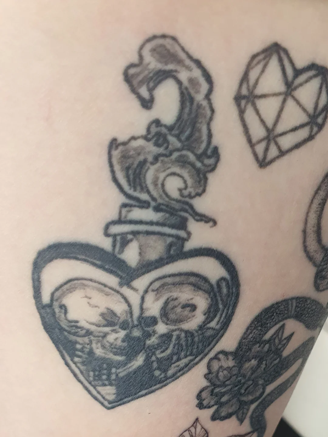 Heart with skull black and grey tattoo on the forearm by Artful Ink