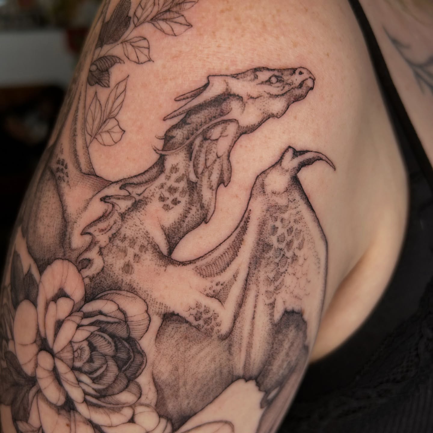 Dragon and flowers dotwork tattoo on the shoulder by Amber Miracle